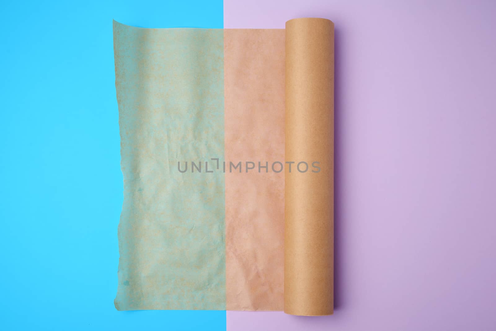 unwrapped a roll of brown parchment paper on a colored background, place for text