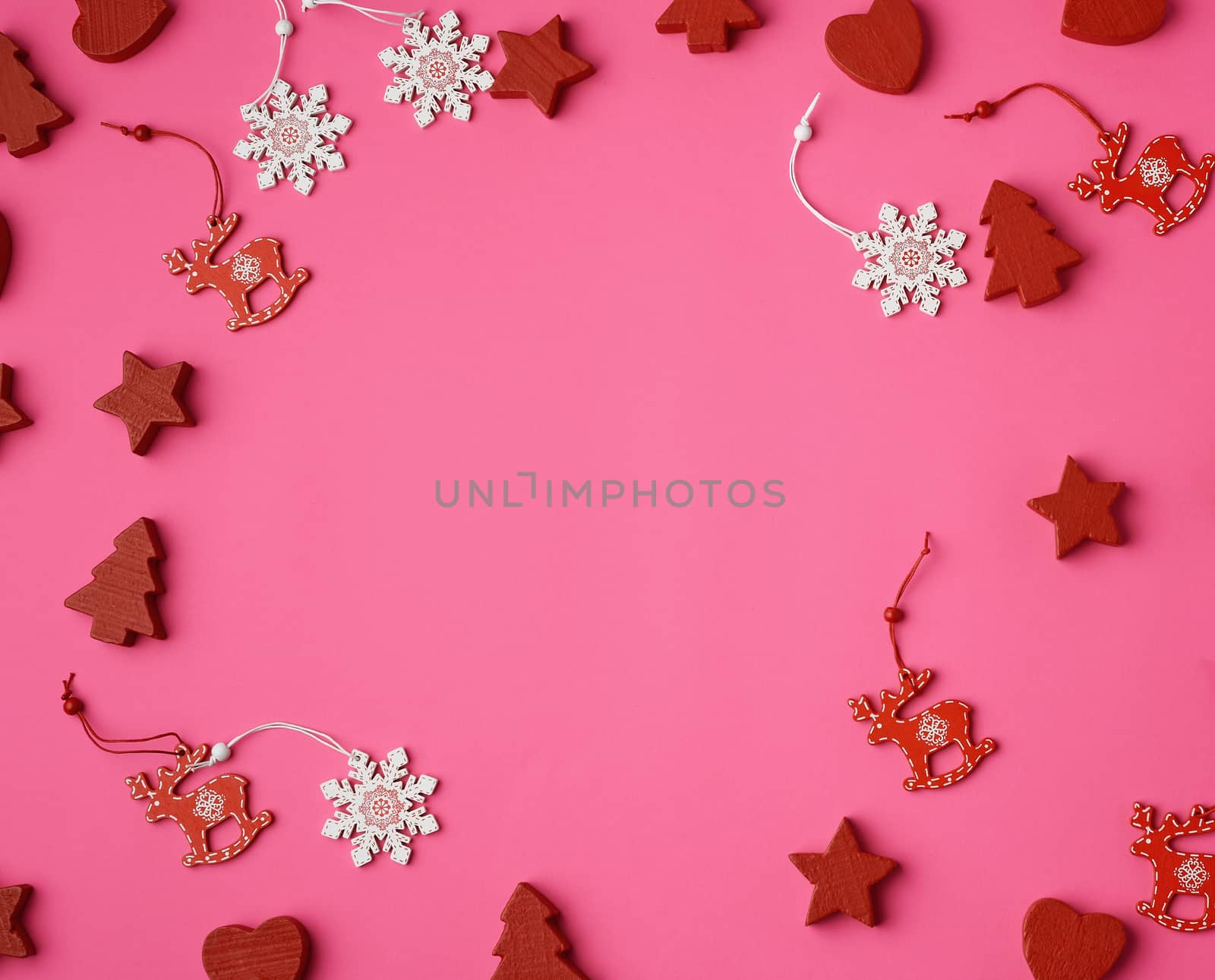 wooden carved Christmas decorations for the holiday tree on a pink background