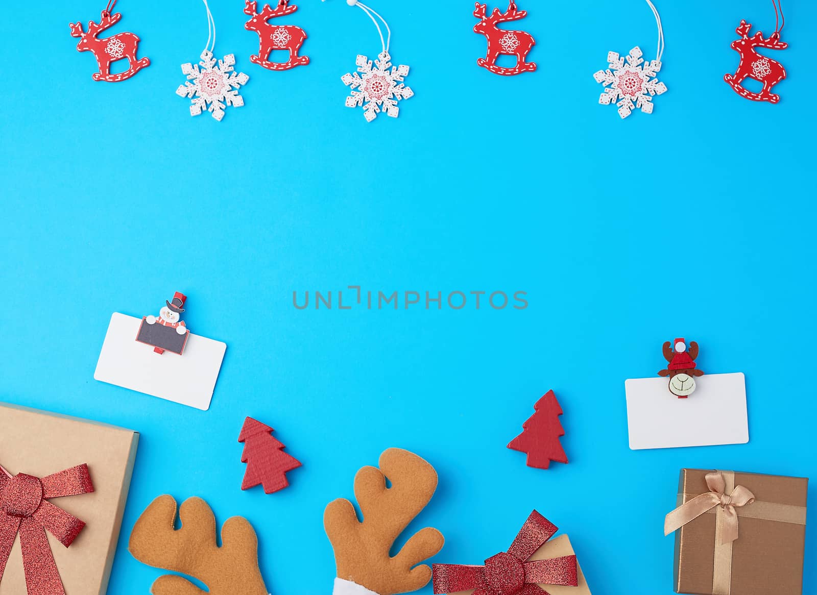  closed square gift boxes with bows on a blue background, top view, place for text
