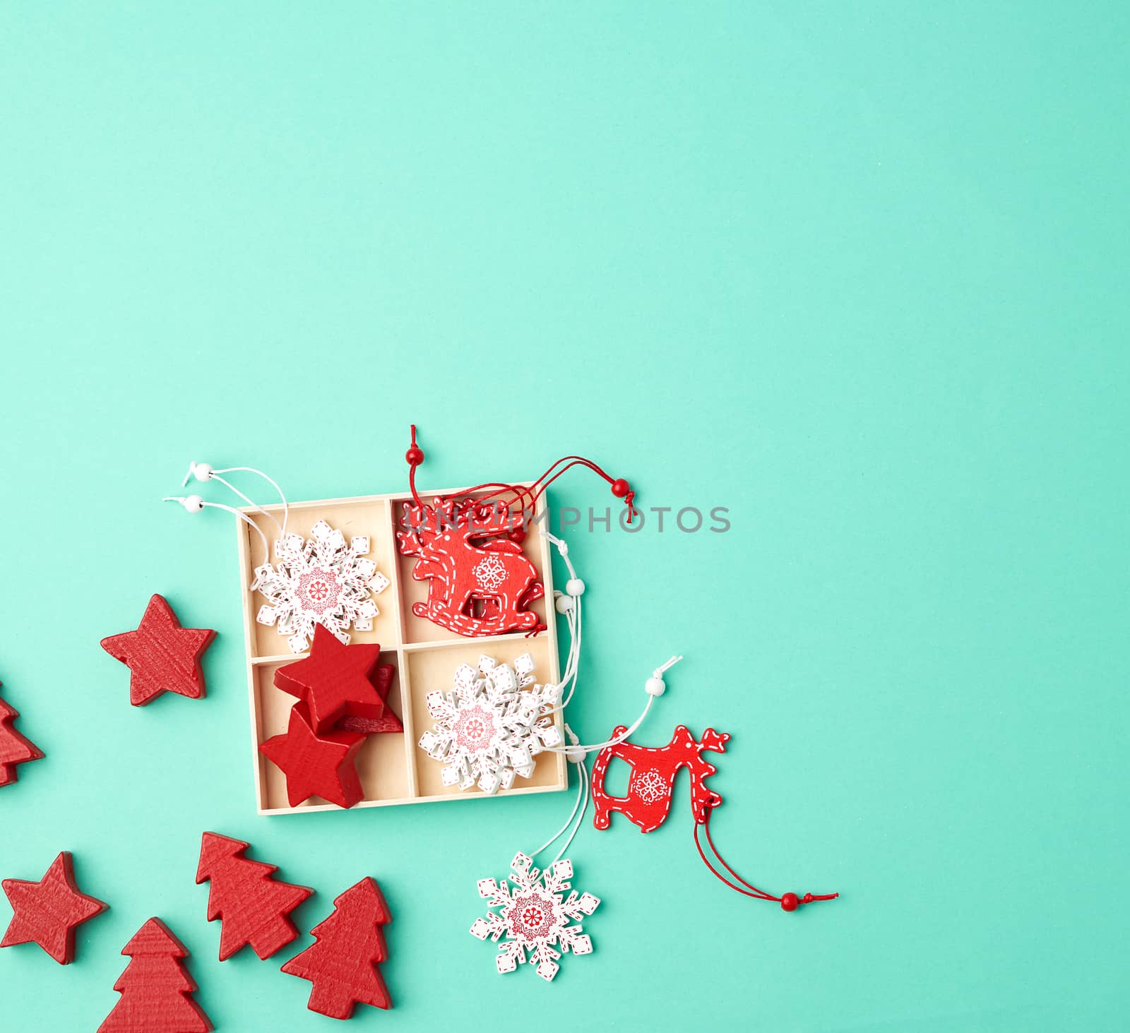 wooden carved Christmas decorations for the holiday tree on a green background, top view