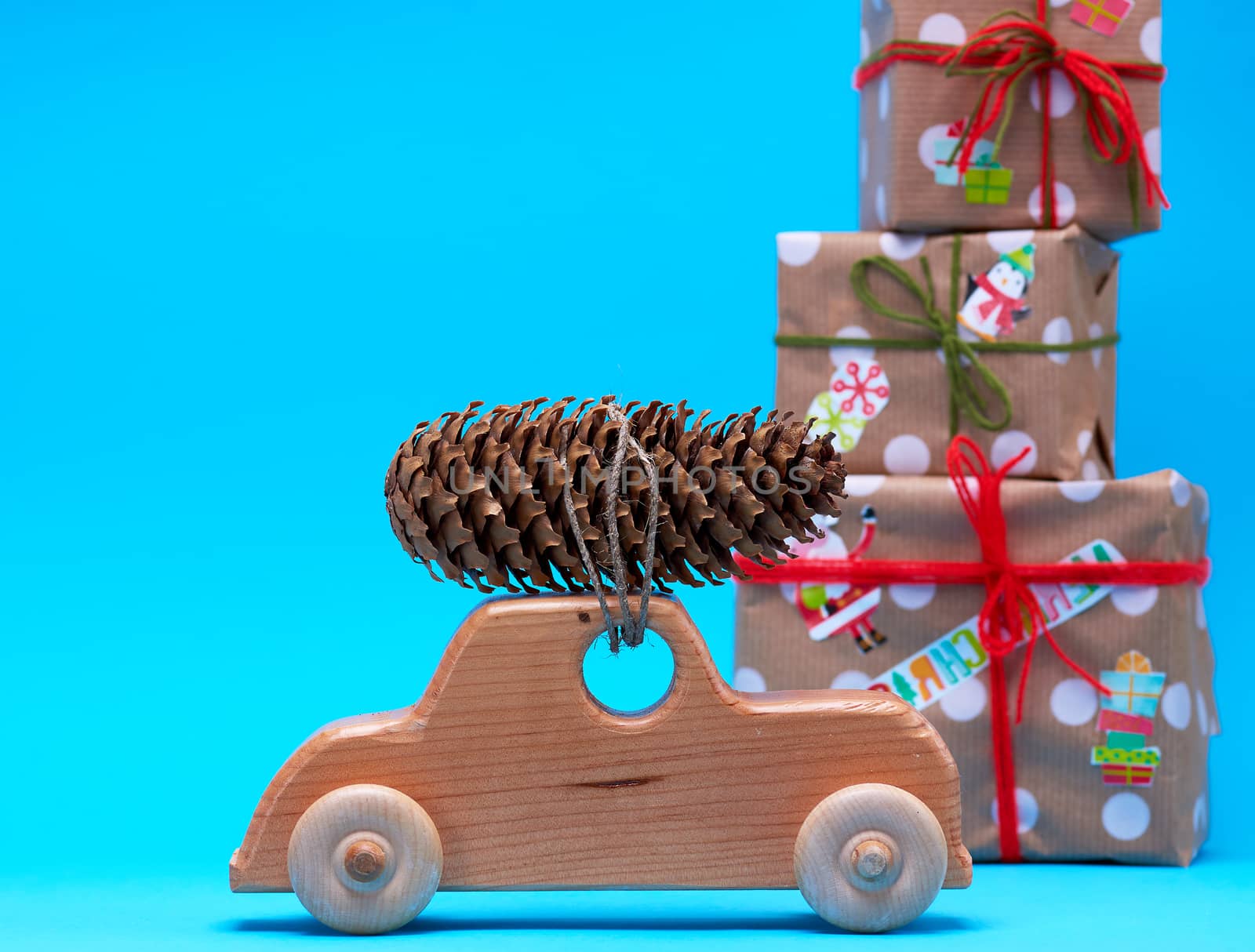 wooden machine carries a rope tied cone against a background of wrapped gifts, Christmas celebration background