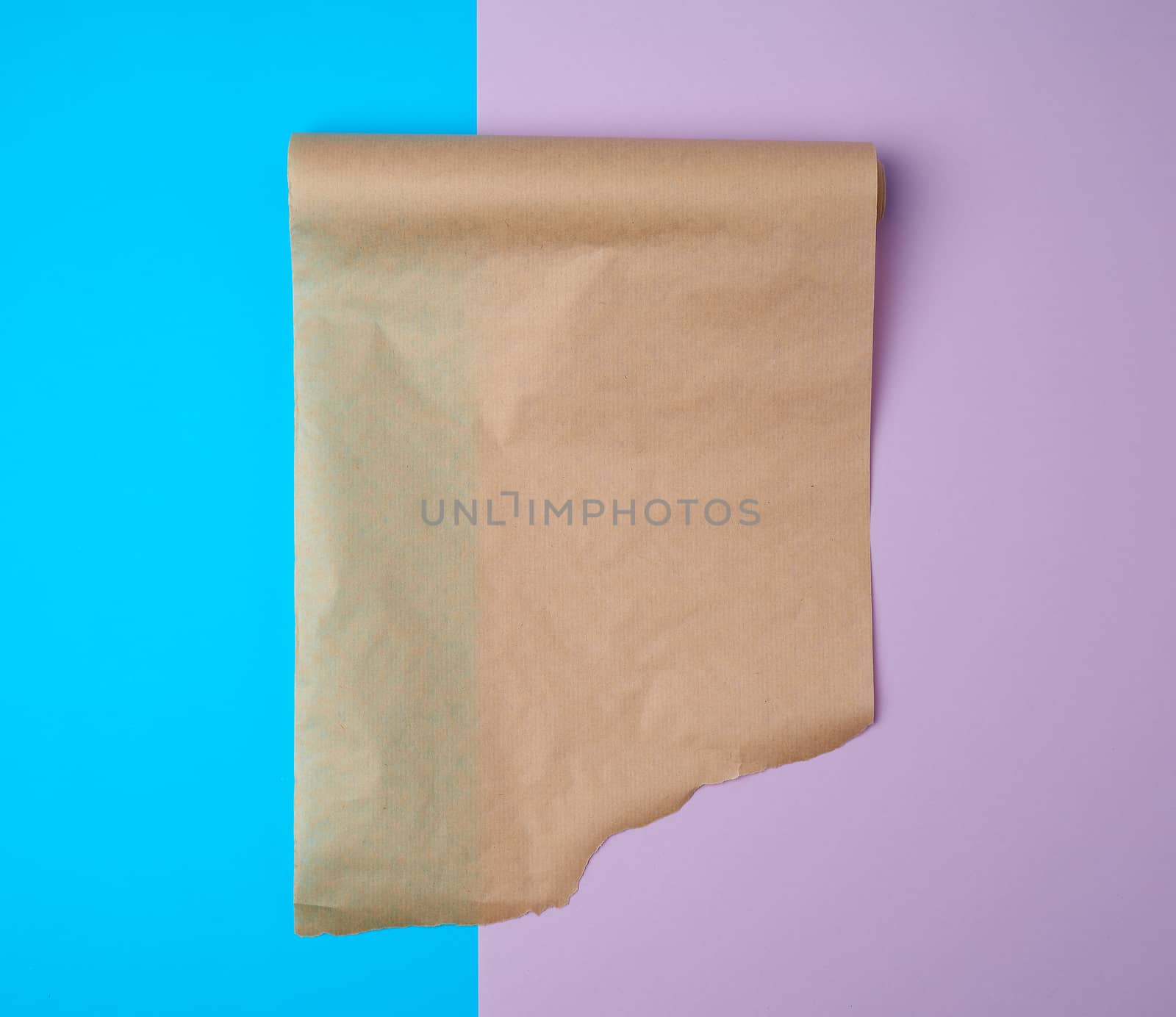 unwrapped a roll of brown parchment paper on a colored background, place for text