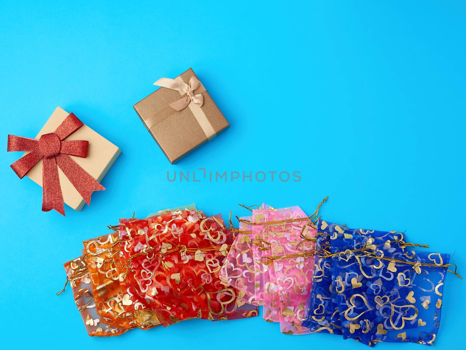 textile gift bags and cardboard boxes on a blue background, top view