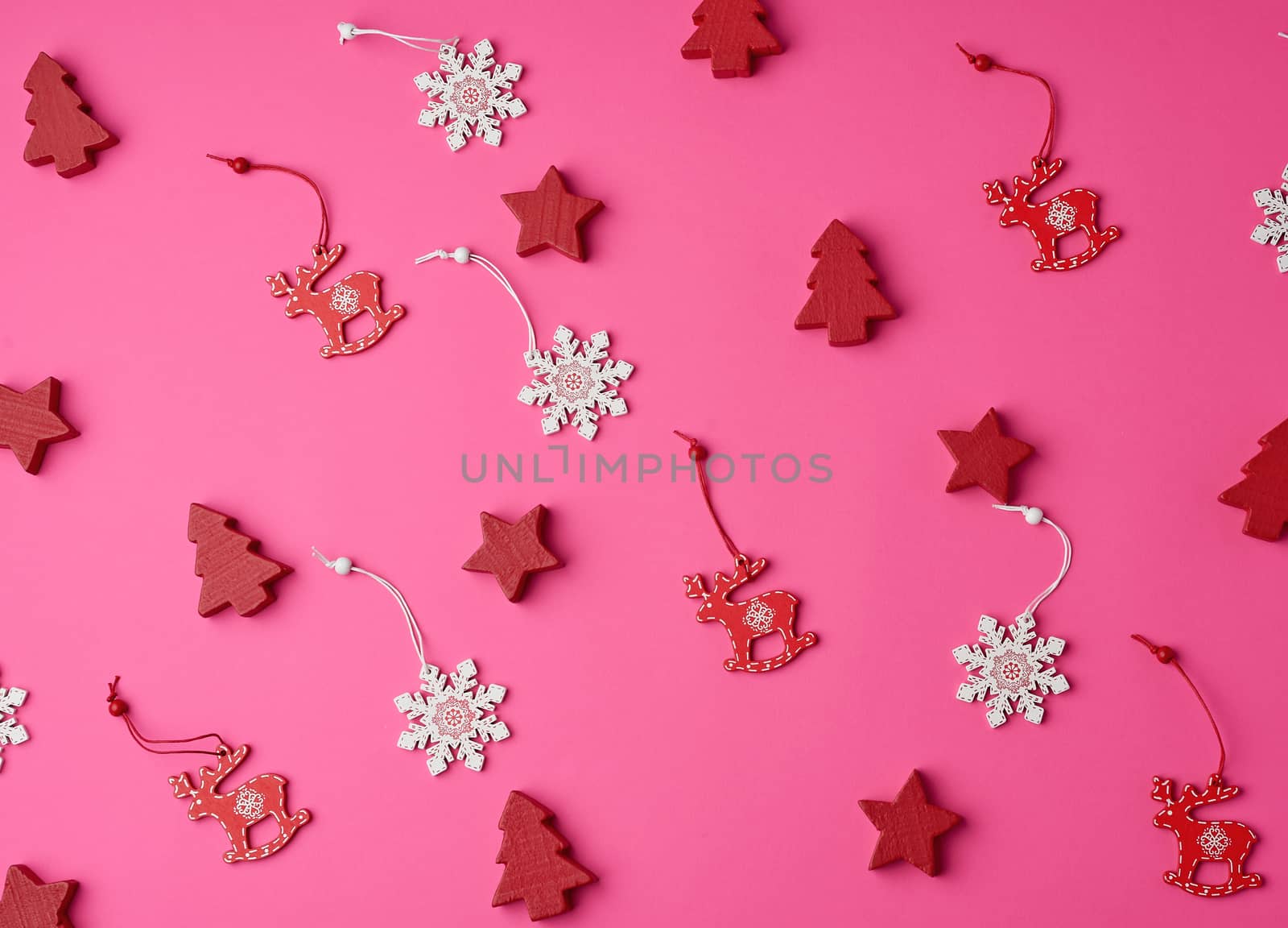 wooden carved Christmas decorations for the holiday tree on a pink background