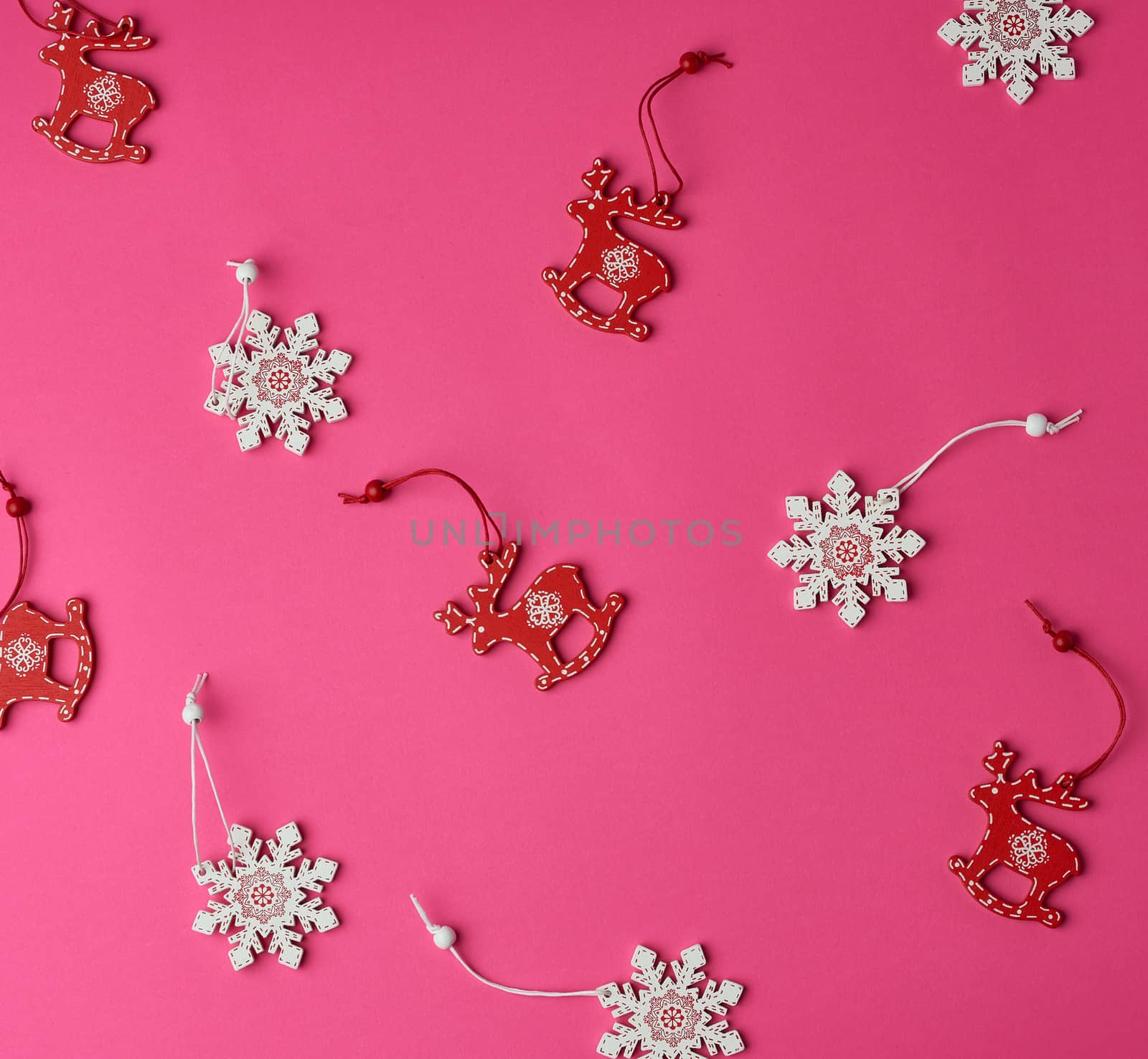 wooden carved Christmas decorations for the holiday tree on a pink background