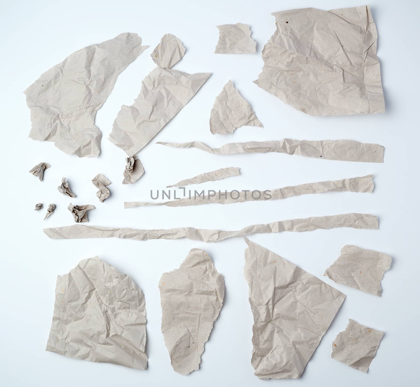 a set of various pieces of torn gray crumpled paper on a white background, close up