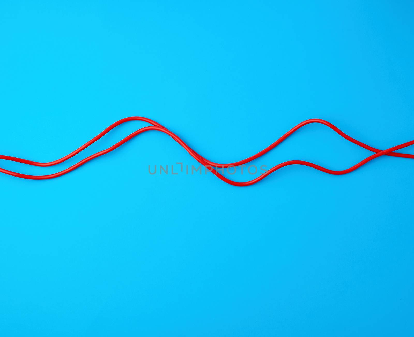 fragment of a red jump rope for sports on a blue background, two lines