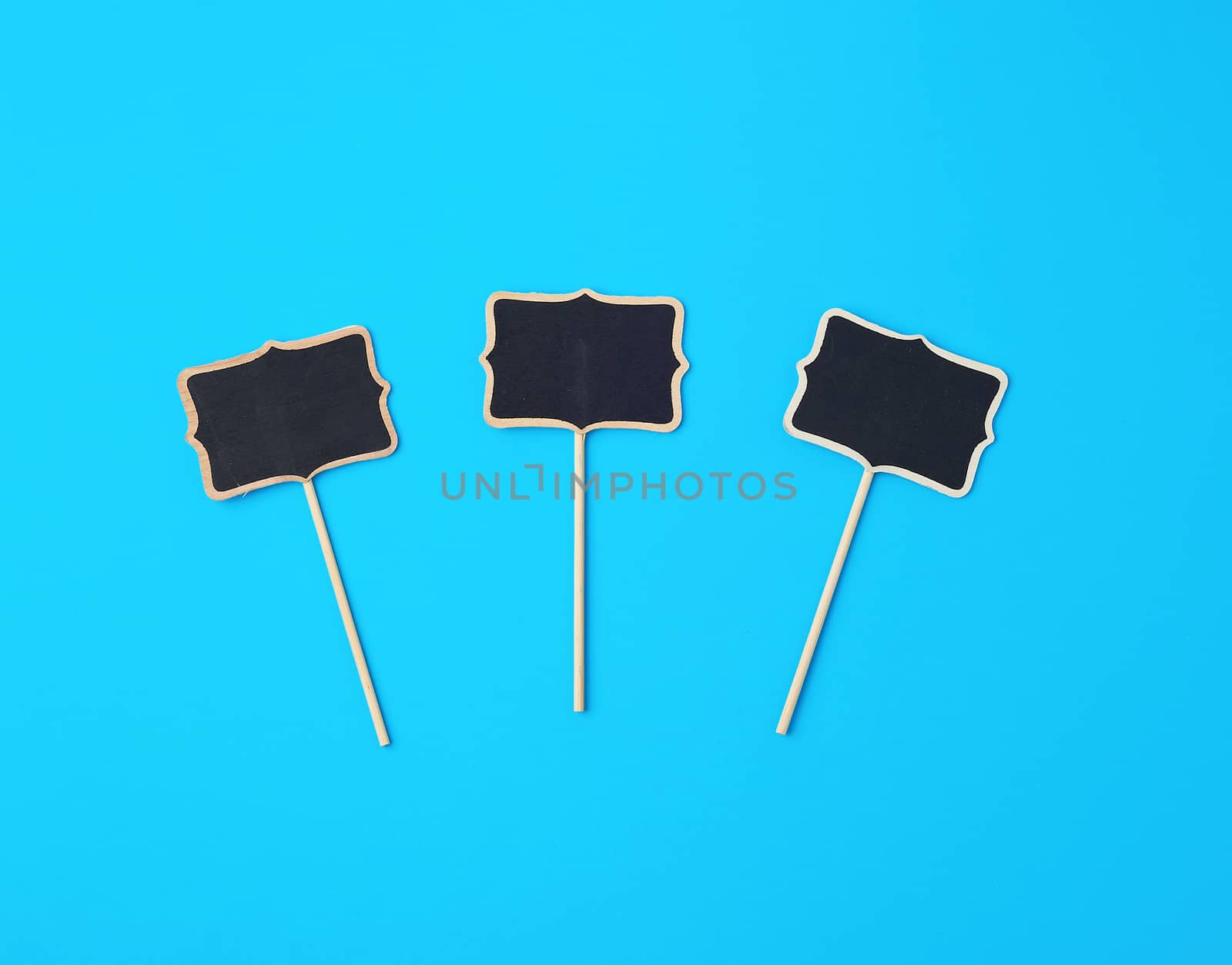 wooden pointer on a stick for writing text, blue background, close up