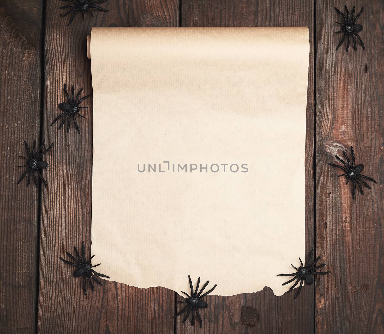 roll of untwisted brown paper on a wooden background, empty place for writing and an invitation to the holiday Halloween