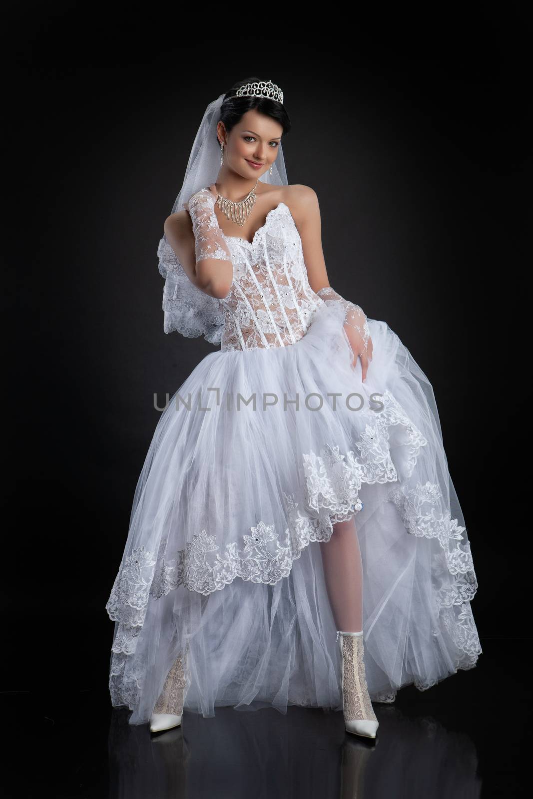 Young beautiful woman in a wedding dress on a studio background