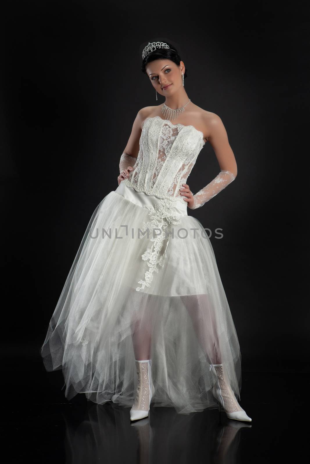 Young beautiful woman in a wedding dress on a studio background