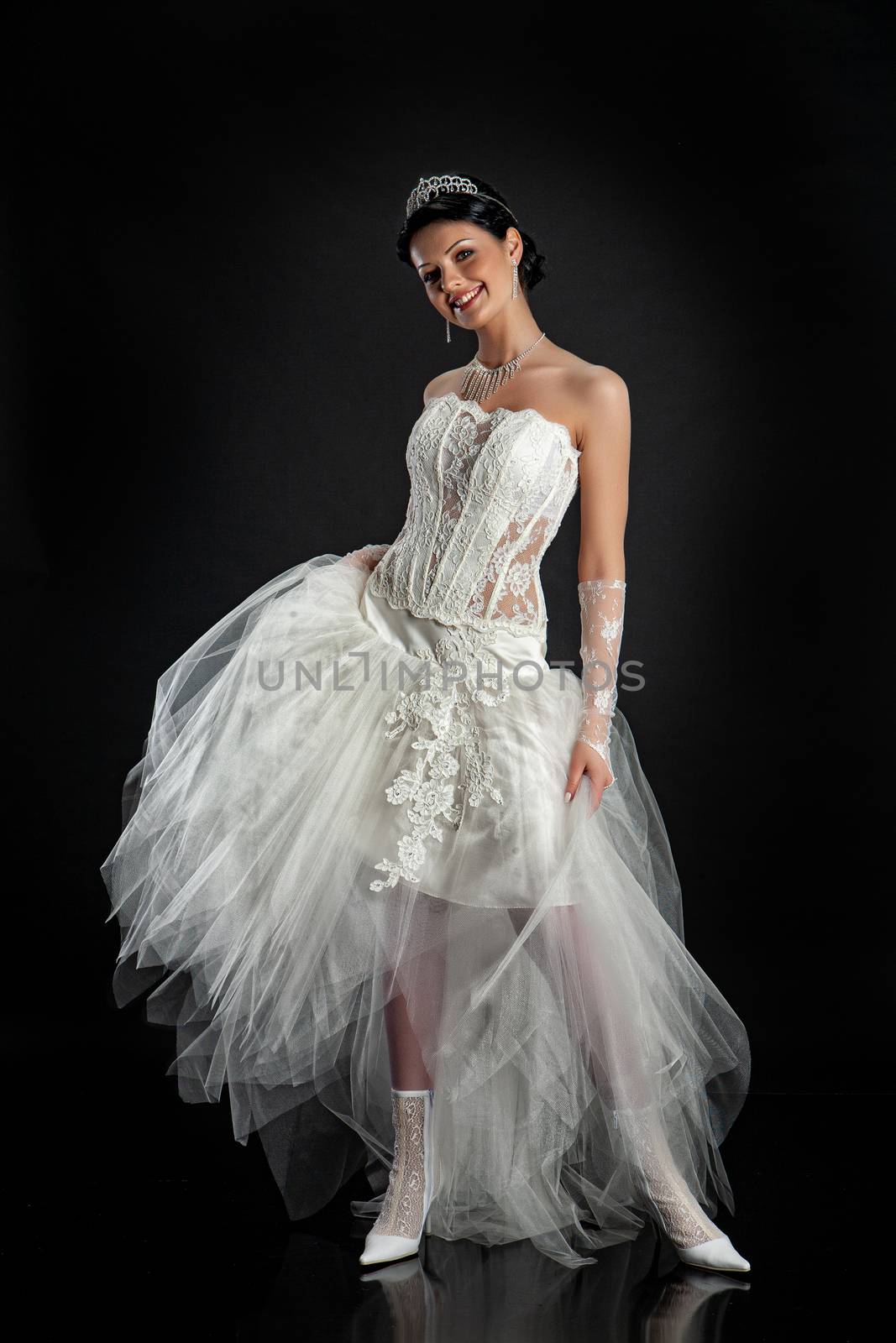 Young beautiful woman in a wedding dress on a studio background