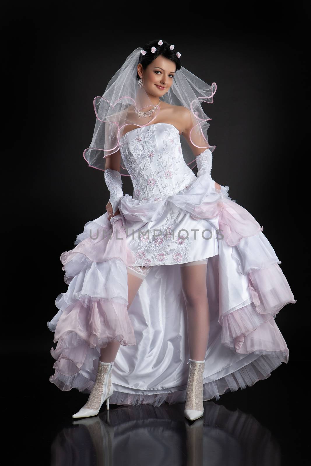Young beautiful woman in a wedding dress on a studio background