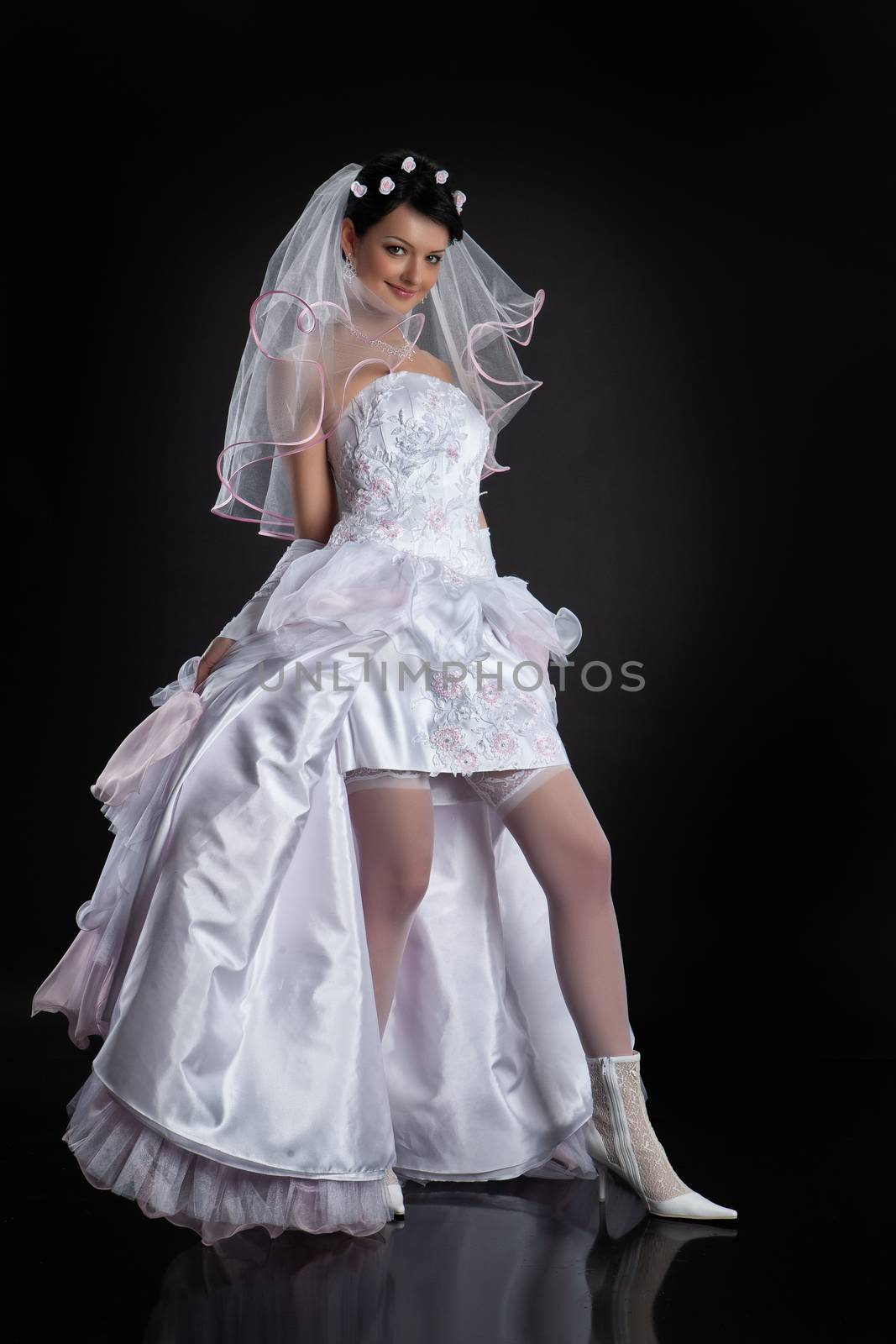 Young beautiful woman in a wedding dress on a studio background