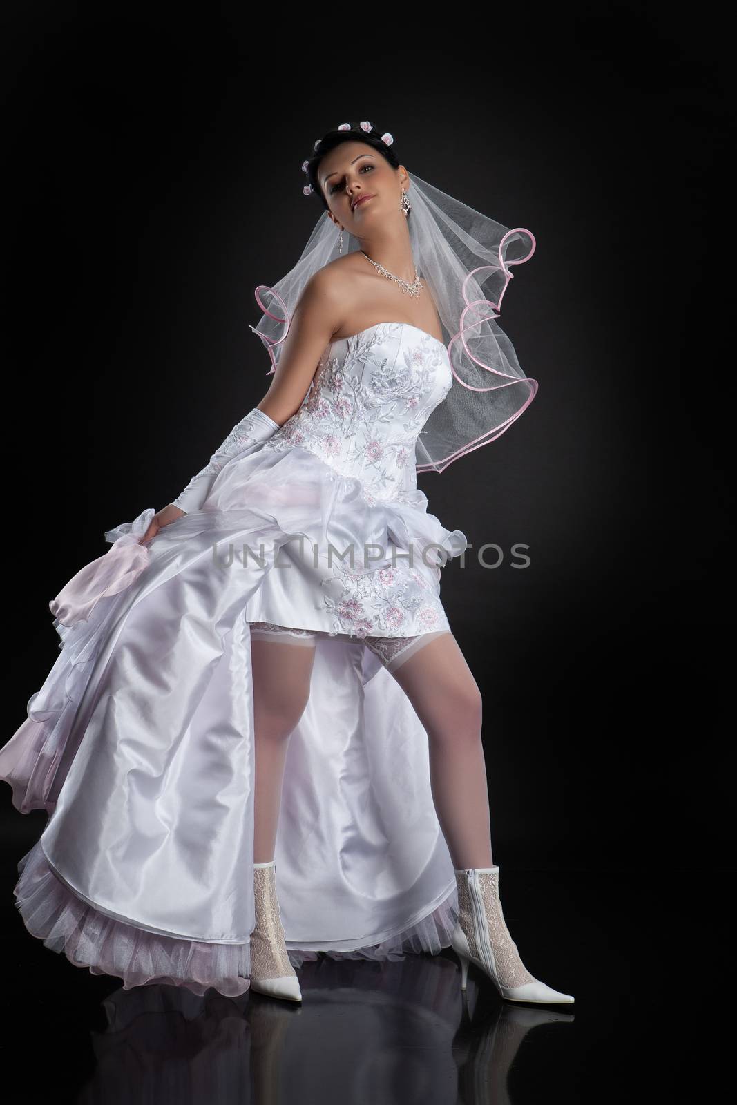 Young beautiful woman in a wedding dress on a studio background