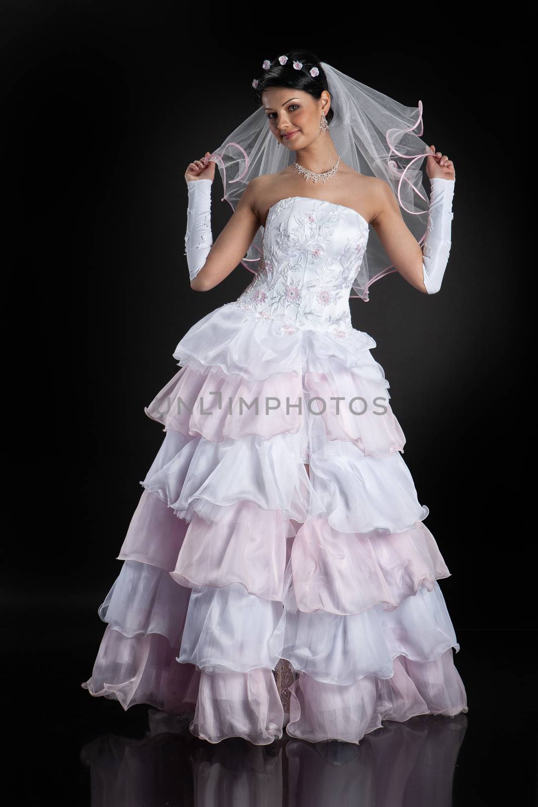 Young beautiful woman in a wedding dress on a studio background