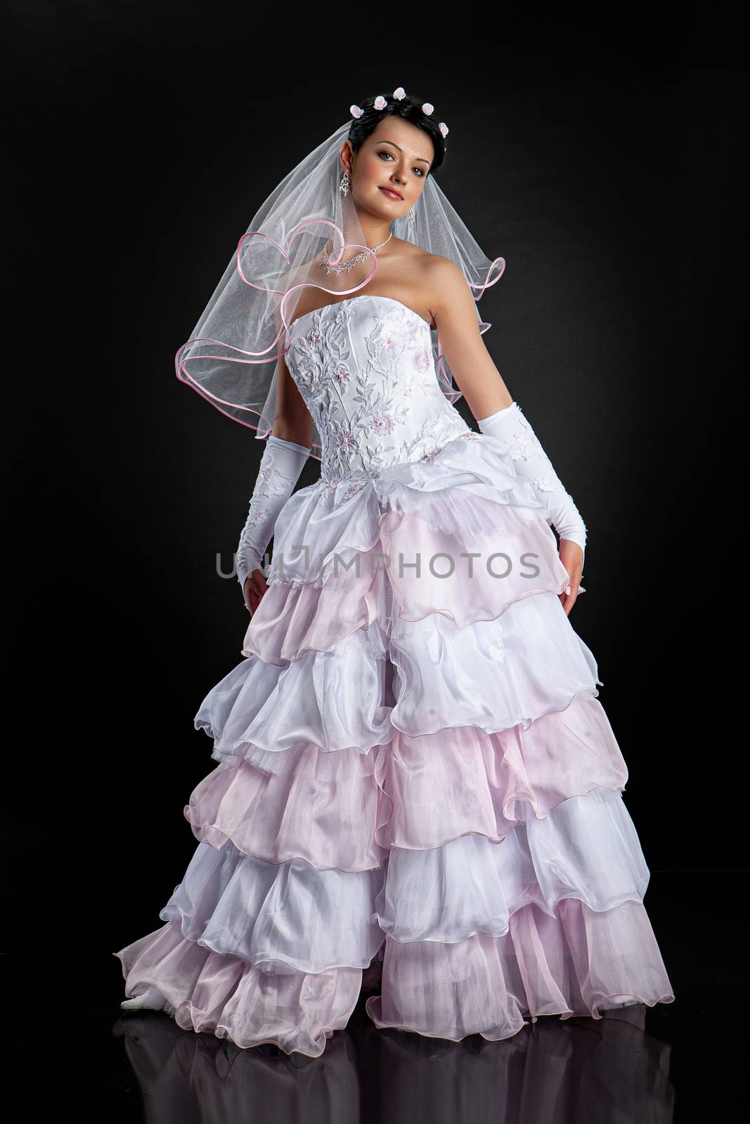 Young beautiful woman in a wedding dress on a studio background