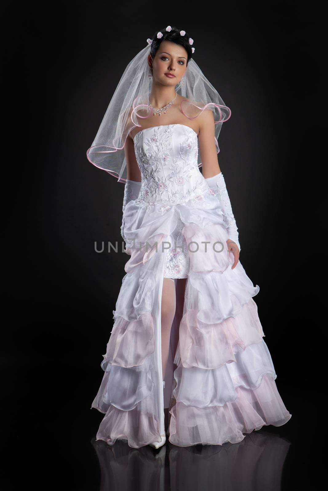 Young beautiful woman in a wedding dress on a studio background