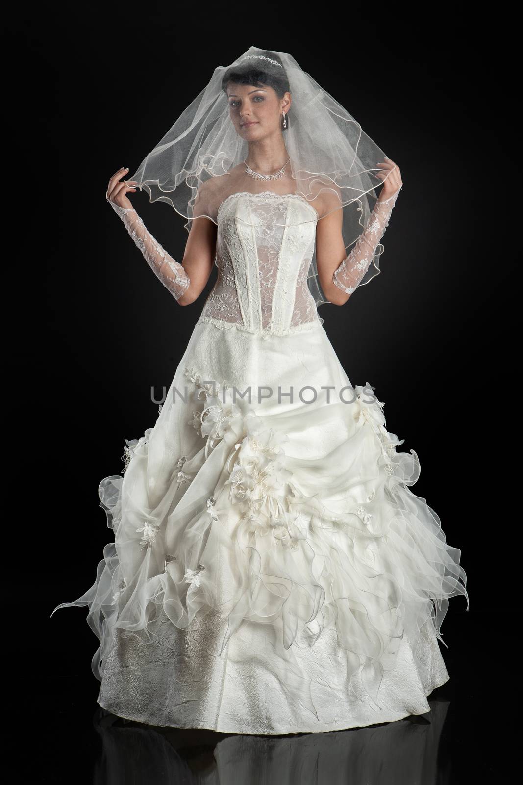 Young beautiful woman in a wedding dress on a studio background