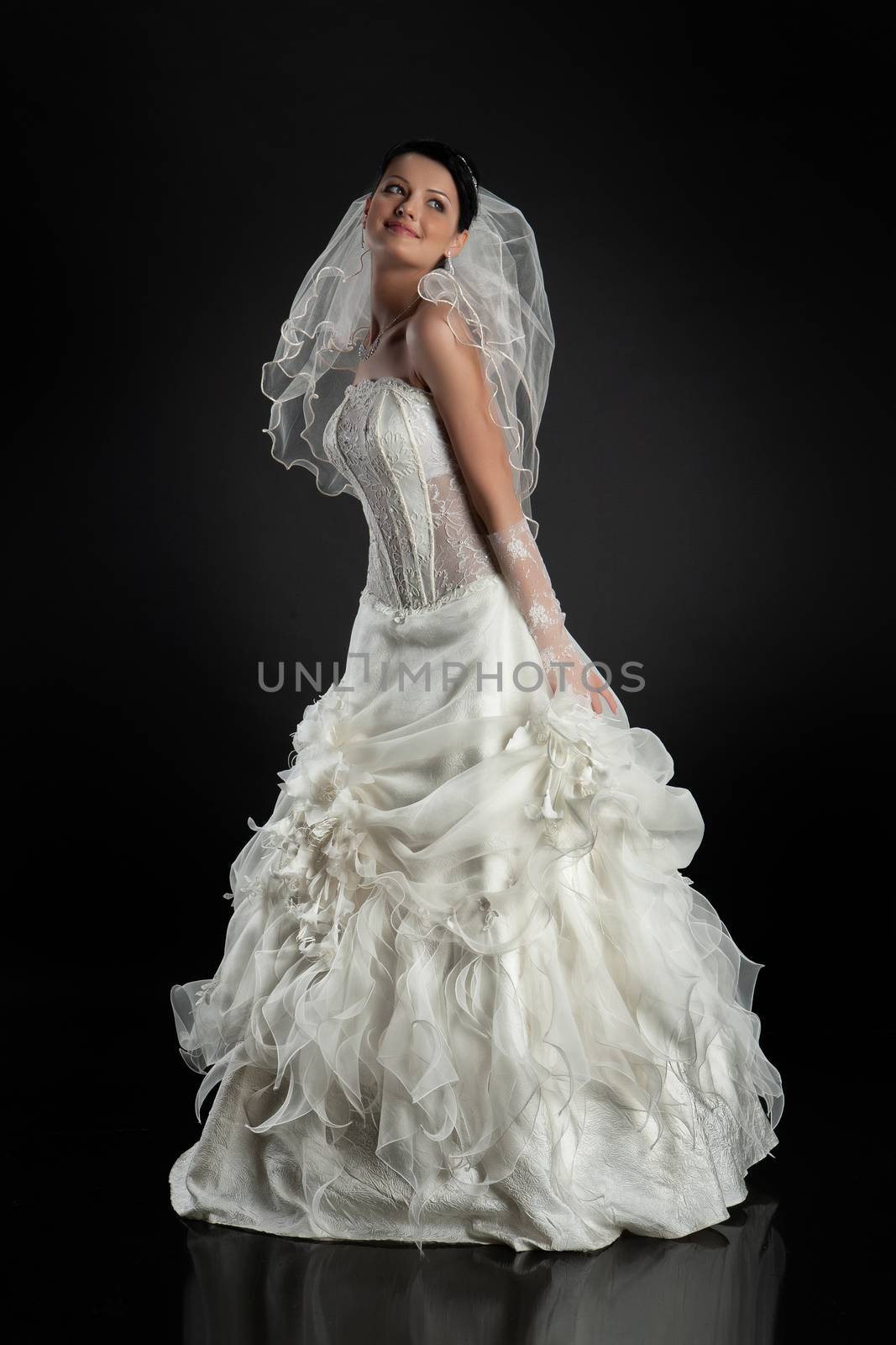 Young beautiful woman in a wedding dress on a studio background