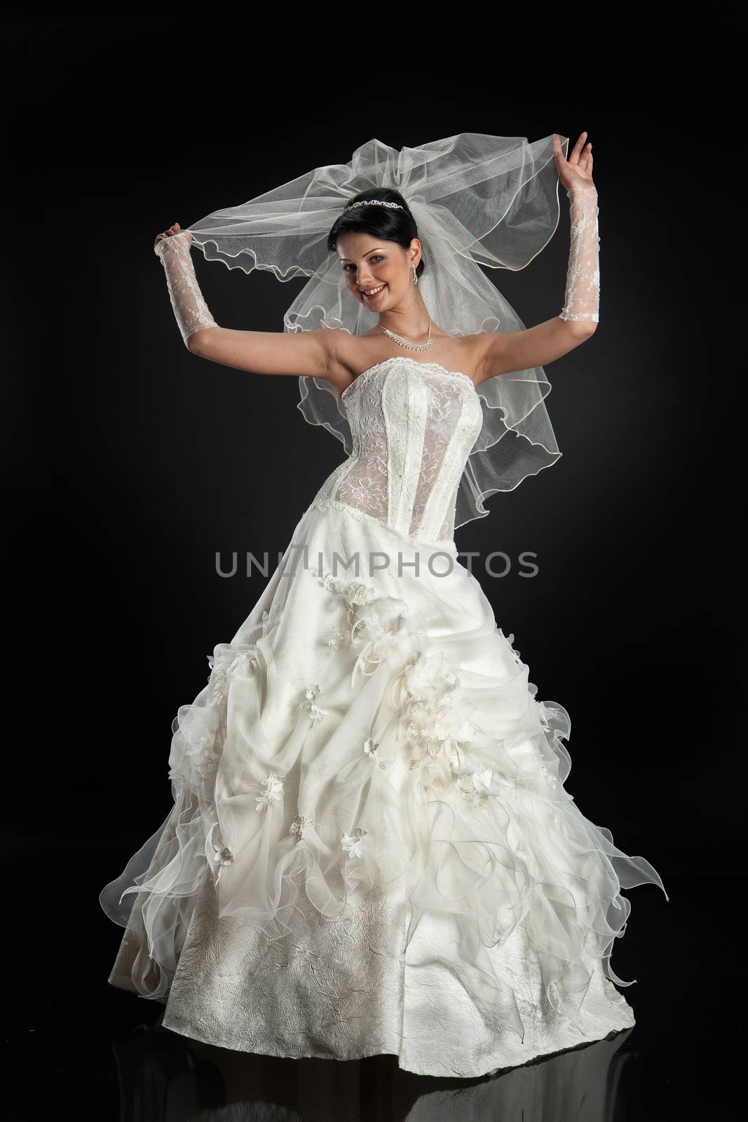 Young beautiful woman in a wedding dress on a studio background
