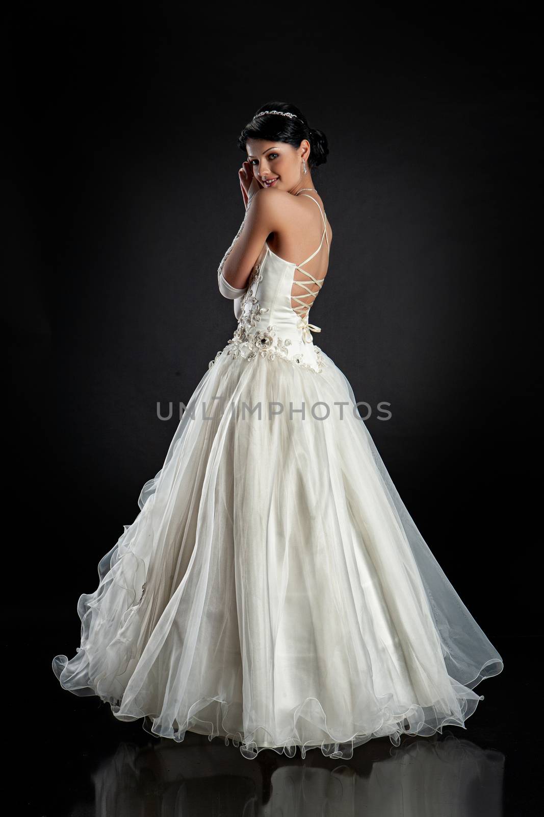 Young beautiful woman in a wedding dress on a studio background