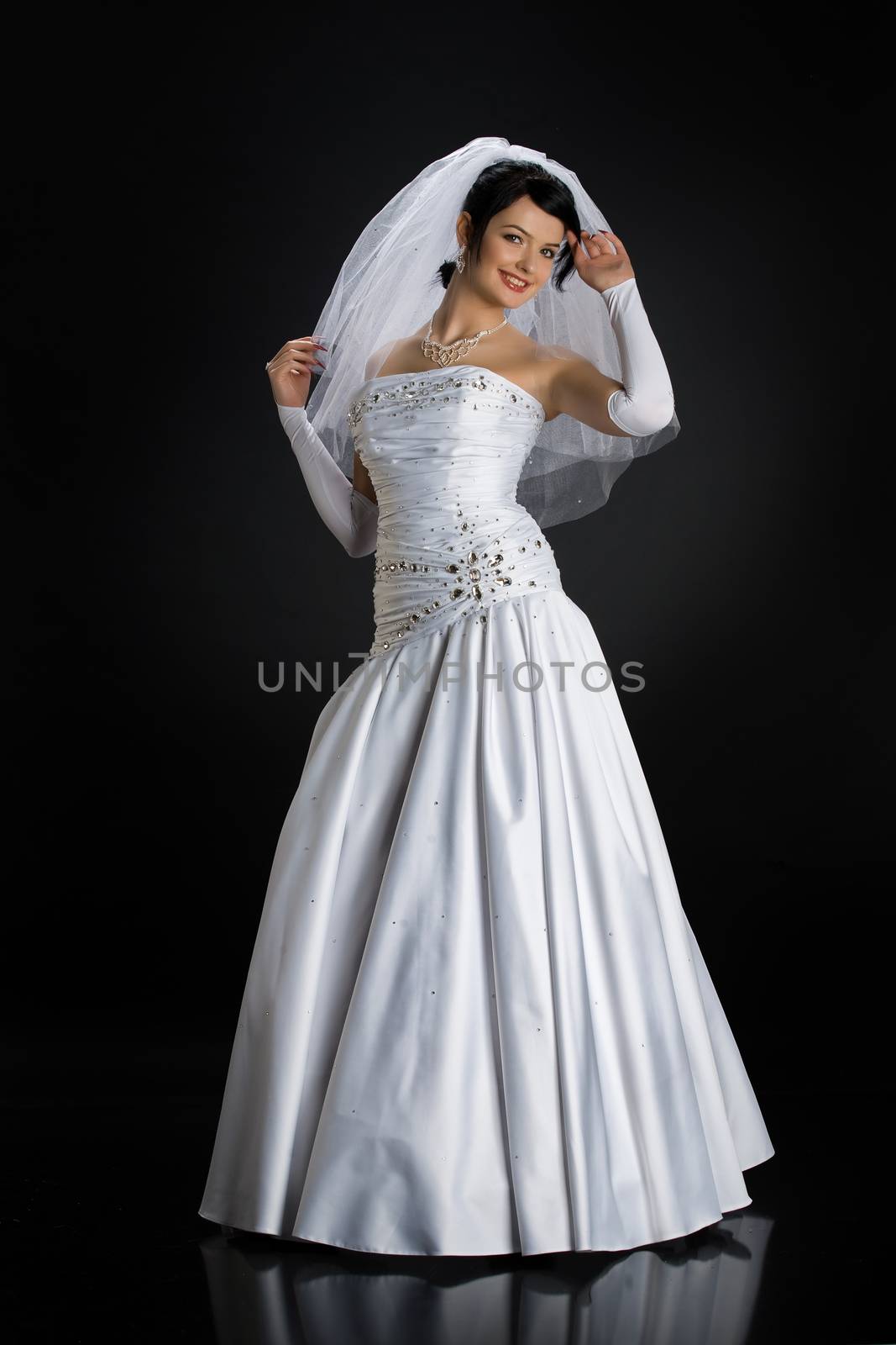 Young beautiful woman in a wedding dress on a studio background