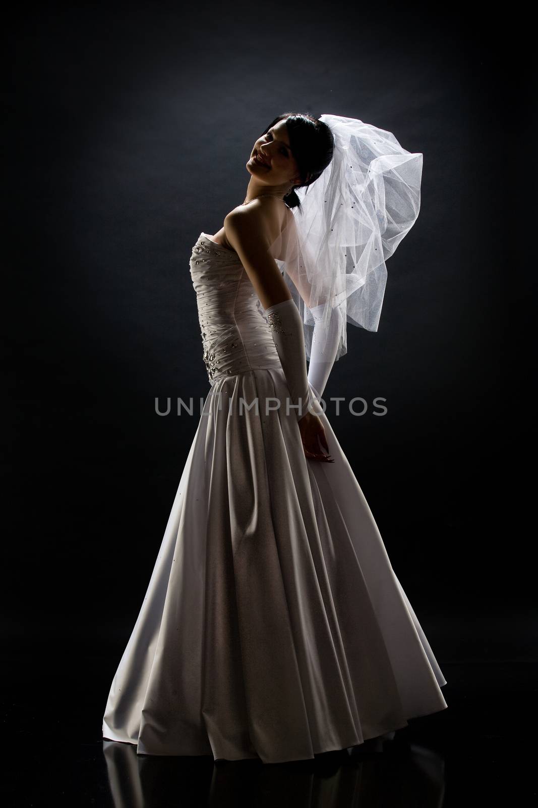 Young beautiful woman in a wedding dress on a studio background