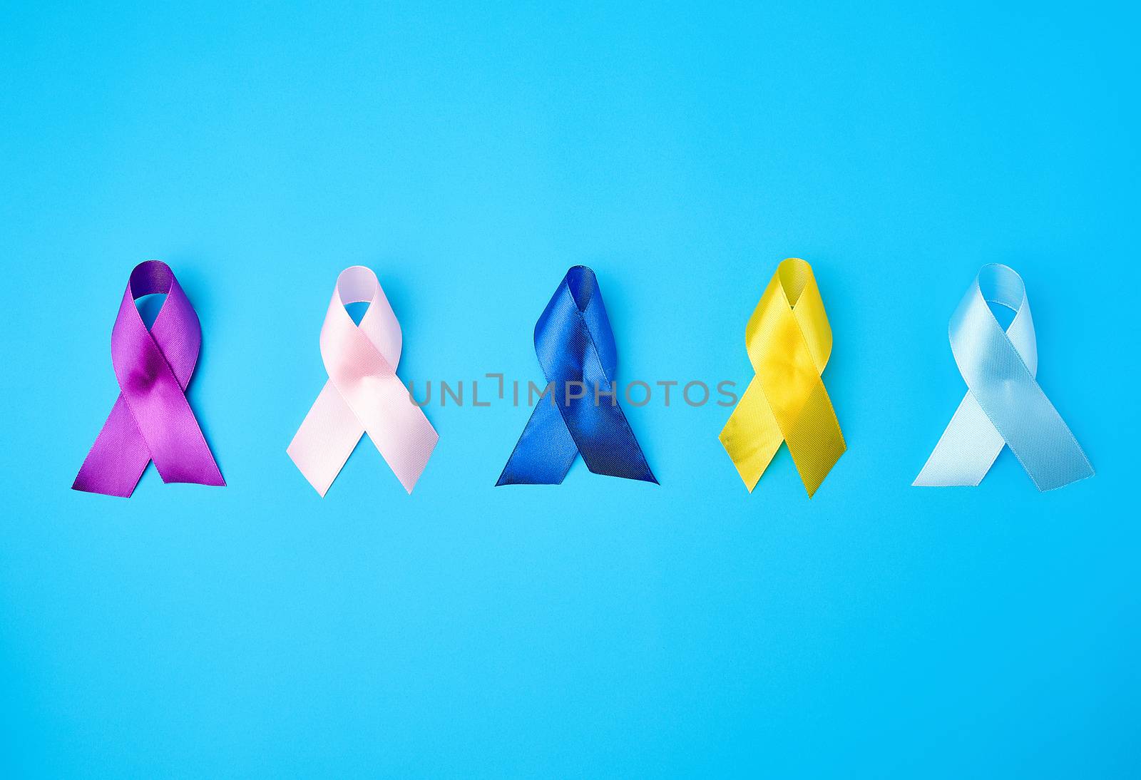 blue, purple, yellow, blue, pink ribbon in the form of a bow, international symbols of diseases on a blue background