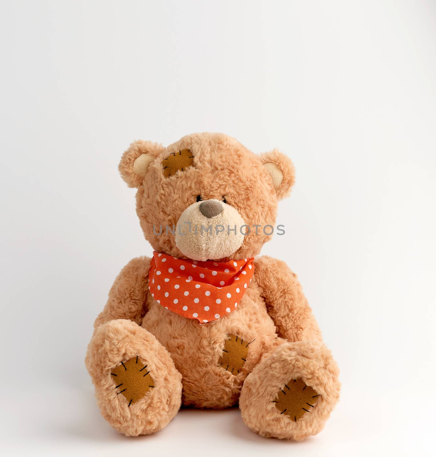 brown vintage teddy bear with patches, white background by ndanko