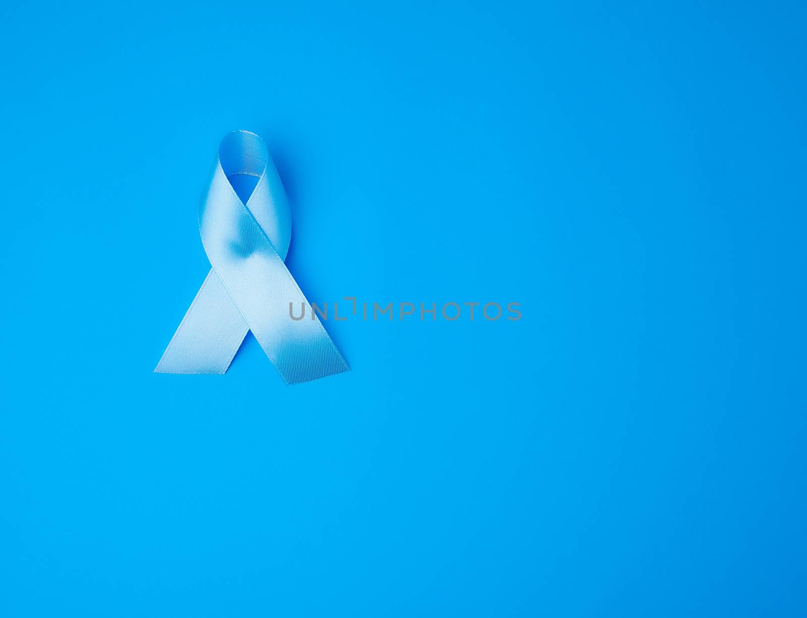 blue ribbon, symbol of the fight and treatment of prostate cancer, copy space