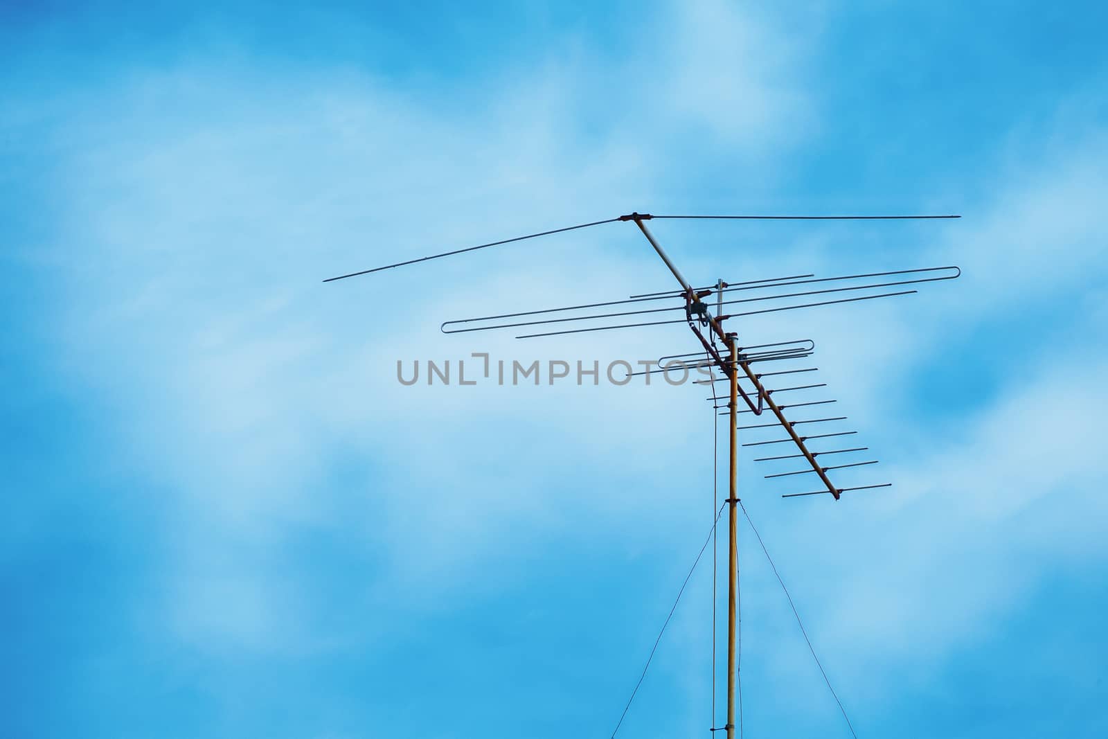 Television antenna on cloudy blue sky