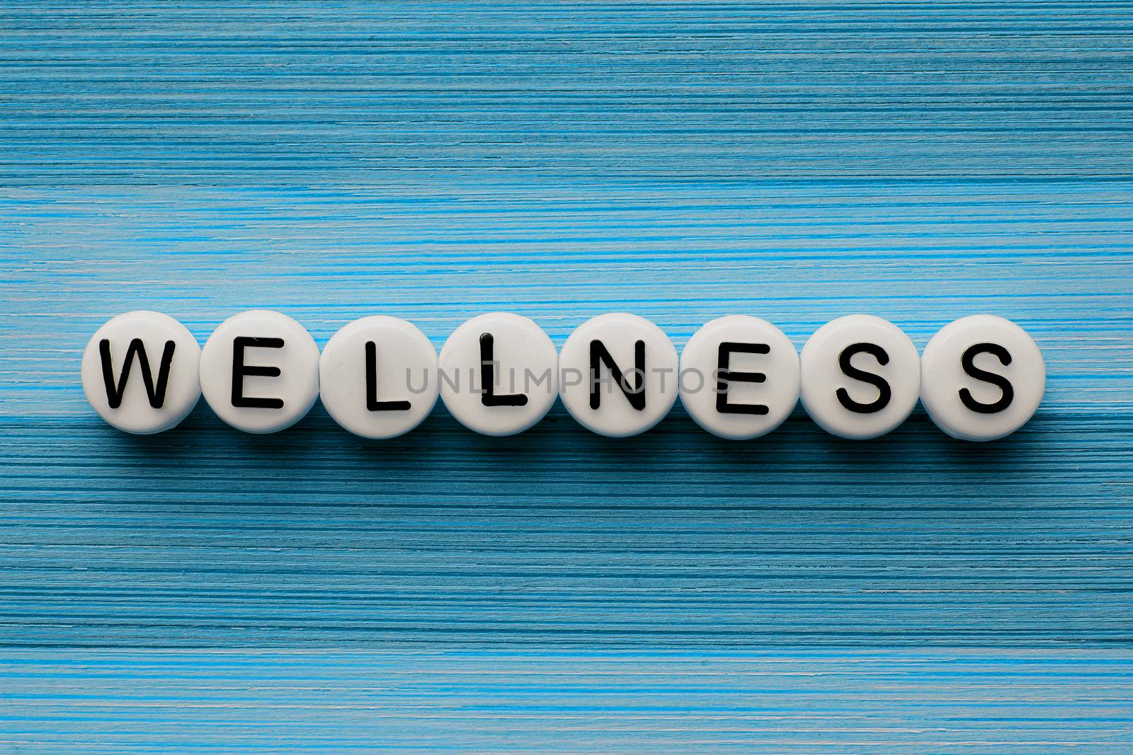 Wellness text on a blue wooden table by oasisamuel