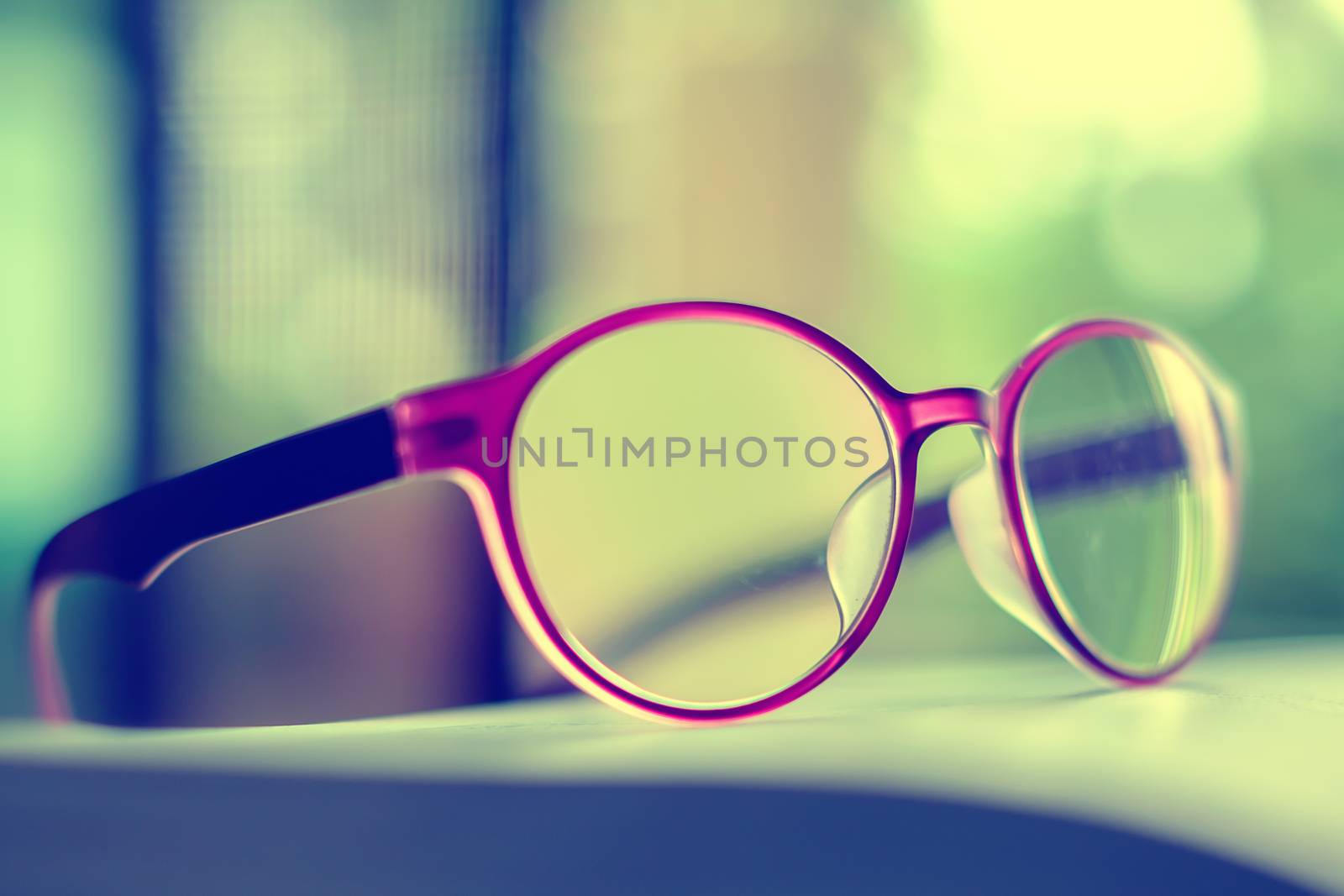 Eyeglasses placed on the book, extremely DOF with vintage retro color tone