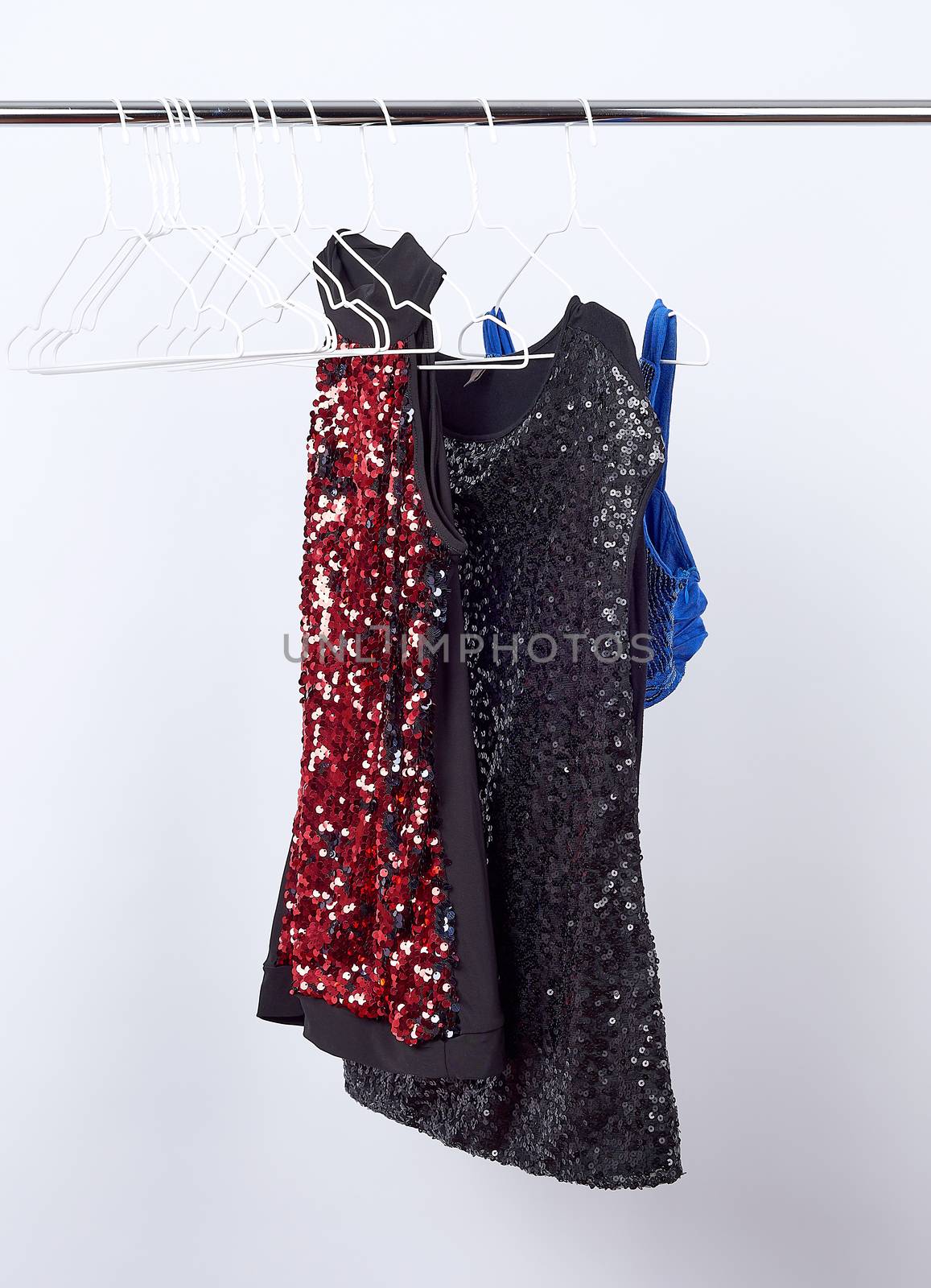 black women's blouses  with red and black sequins hanging on a white iron hanger, sale concept