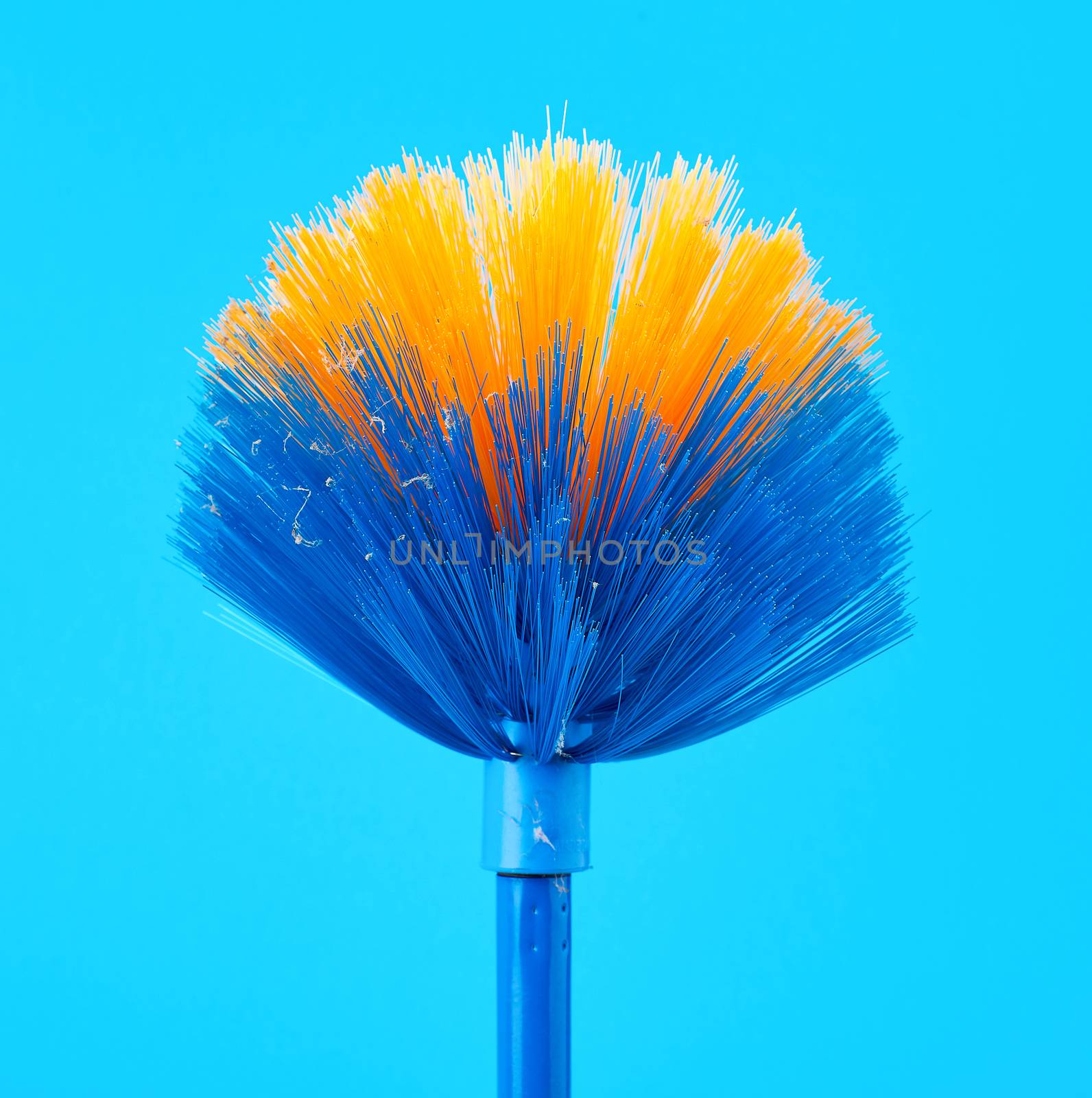 blue-yellow mop broom for collecting dust on a stick, blue background