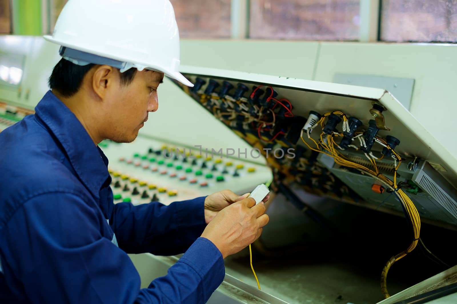 Engineer checking and repairing the electrical system in the control room