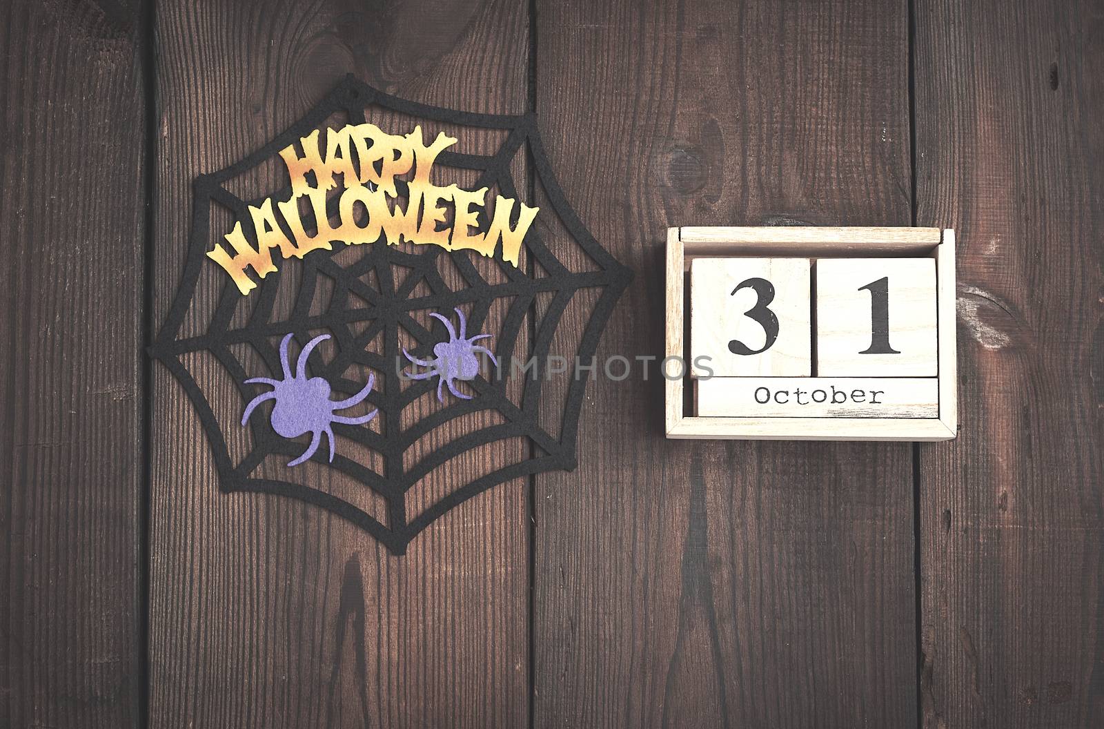 felt figures of the web, spider for the holiday of Halloween on a brown background, top view