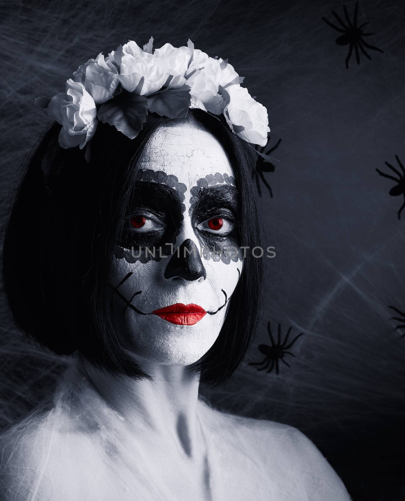 Young beautiful girl with traditional mexican death mask. Calavera Catrina. Sugar skull makeup. girl dressed in a wreath of white roses 