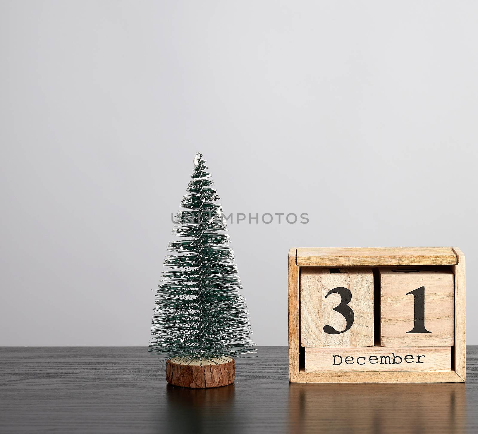 wooden calendar of cubes with the date of December 31 and green tree, festive  background