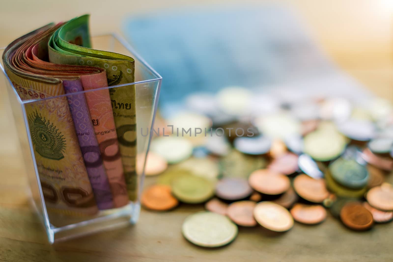 Thai baht money banknotes and coins on the wood table, business and finance concept