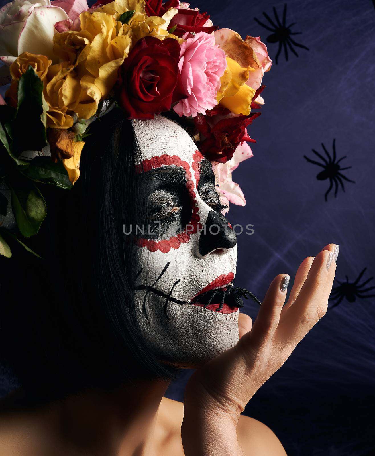 Young beautiful girl with traditional mexican death mask. Calavera Catrina. Sugar skull makeup. girl dressed in a wreath of roses on a background of white web