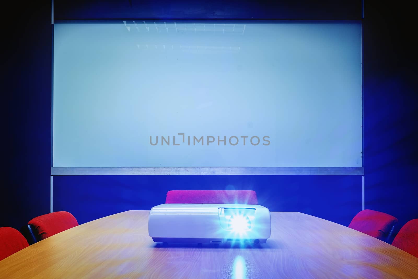 Meeting room with blue light from projector on the table