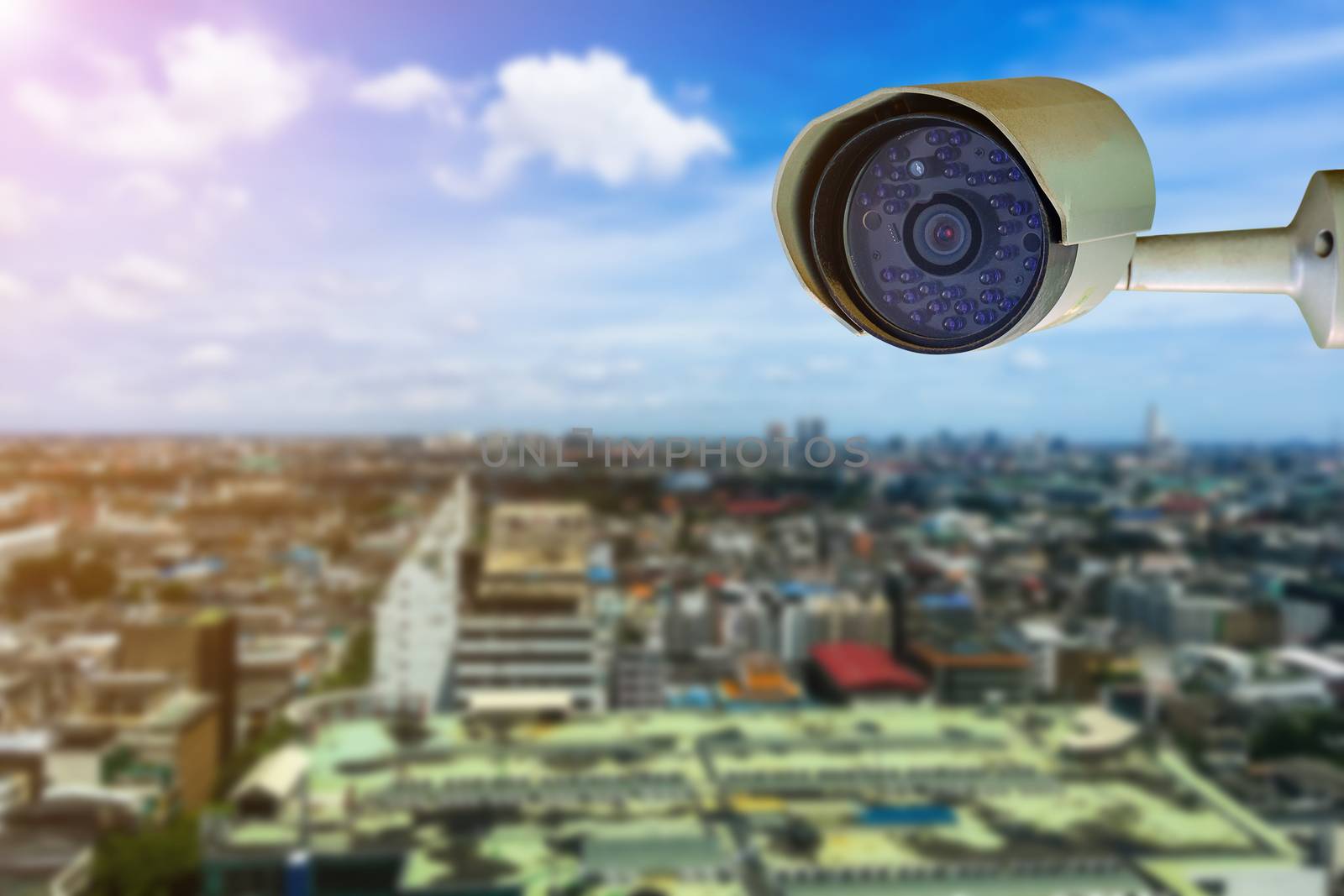 Dirty CCTV security camera with blurred cityscape background