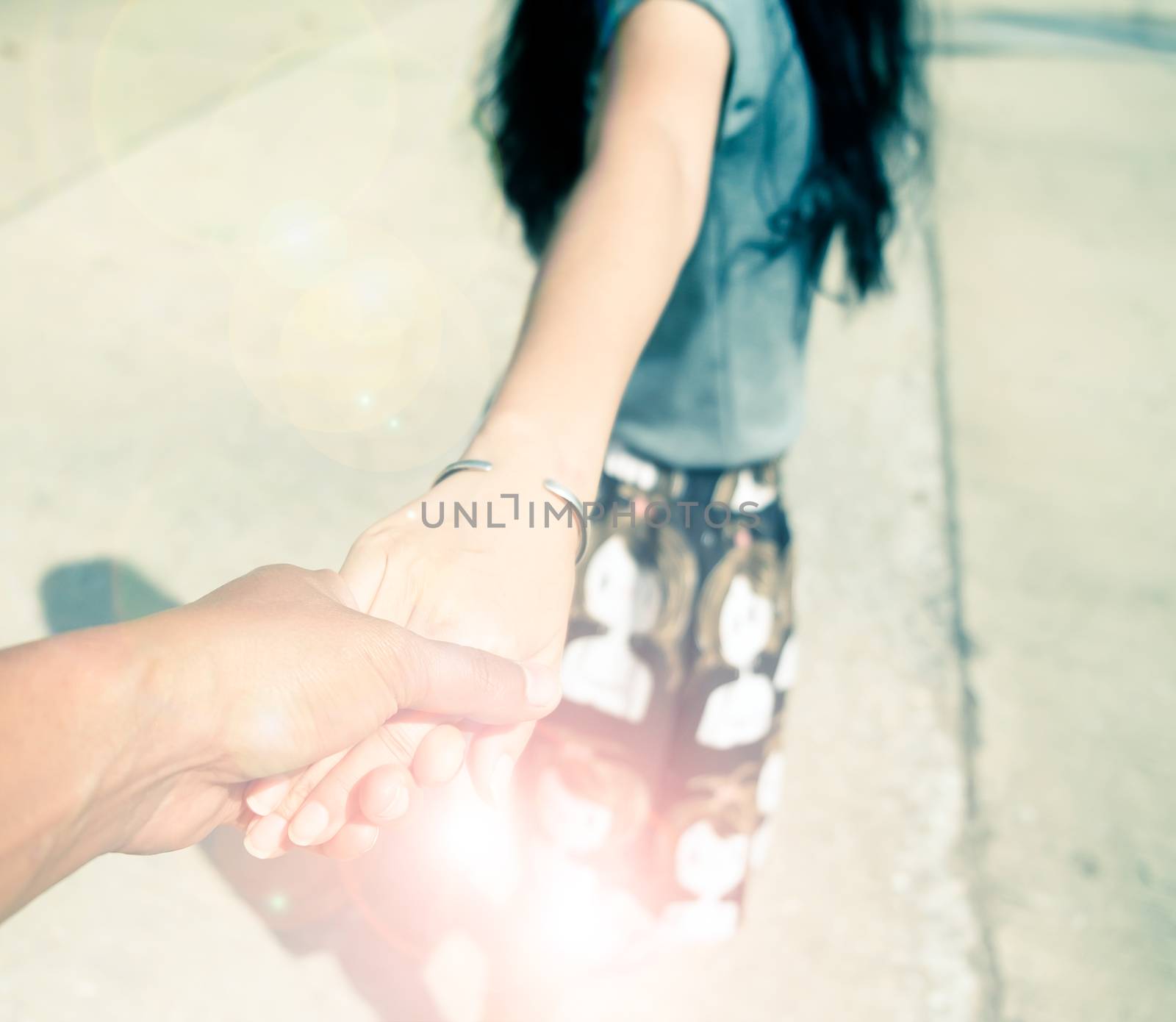 Loving couple holding hands and walking together with color filter effect.