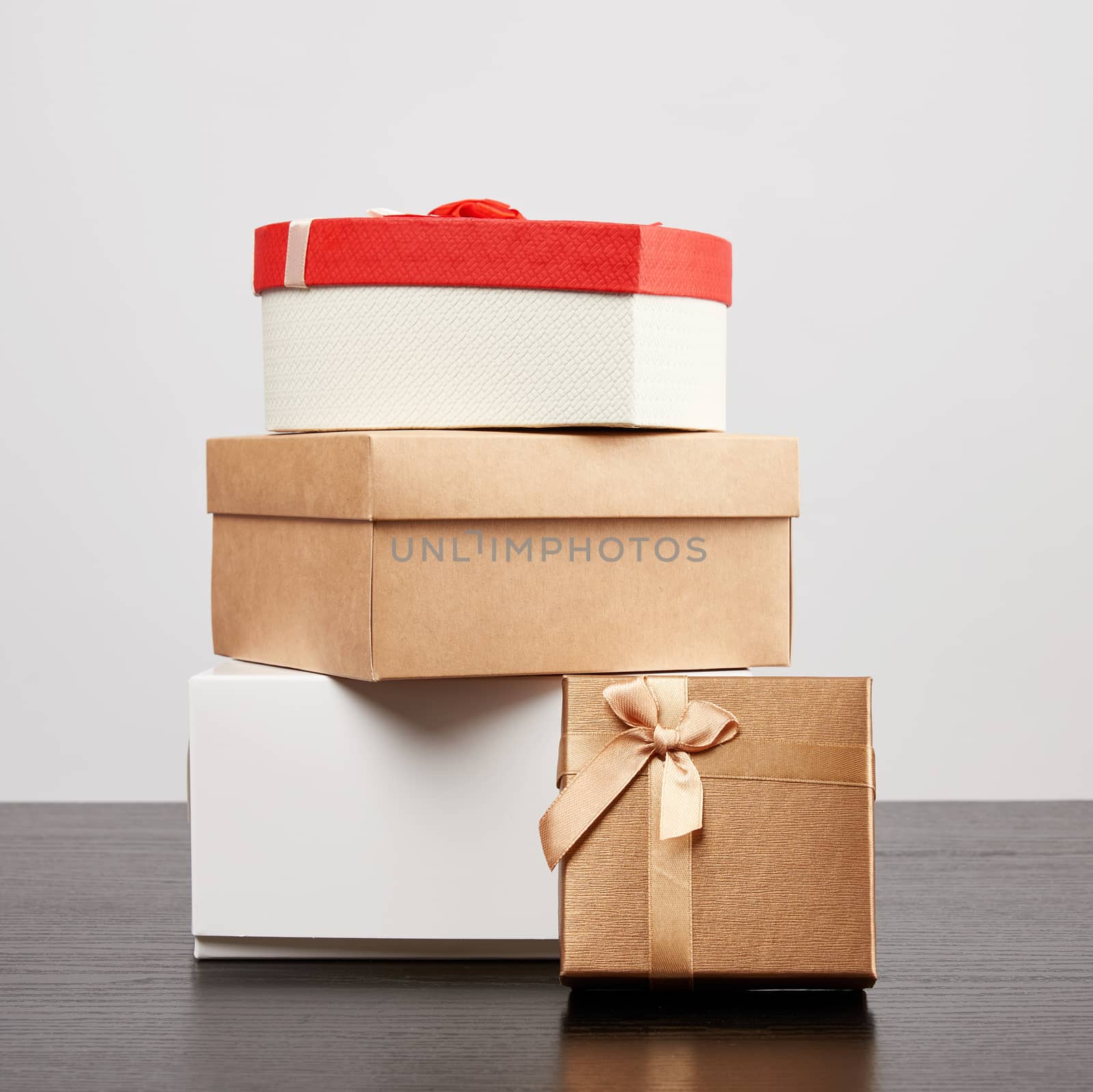 stack of various cardboard boxes for gifts on a black table, white background