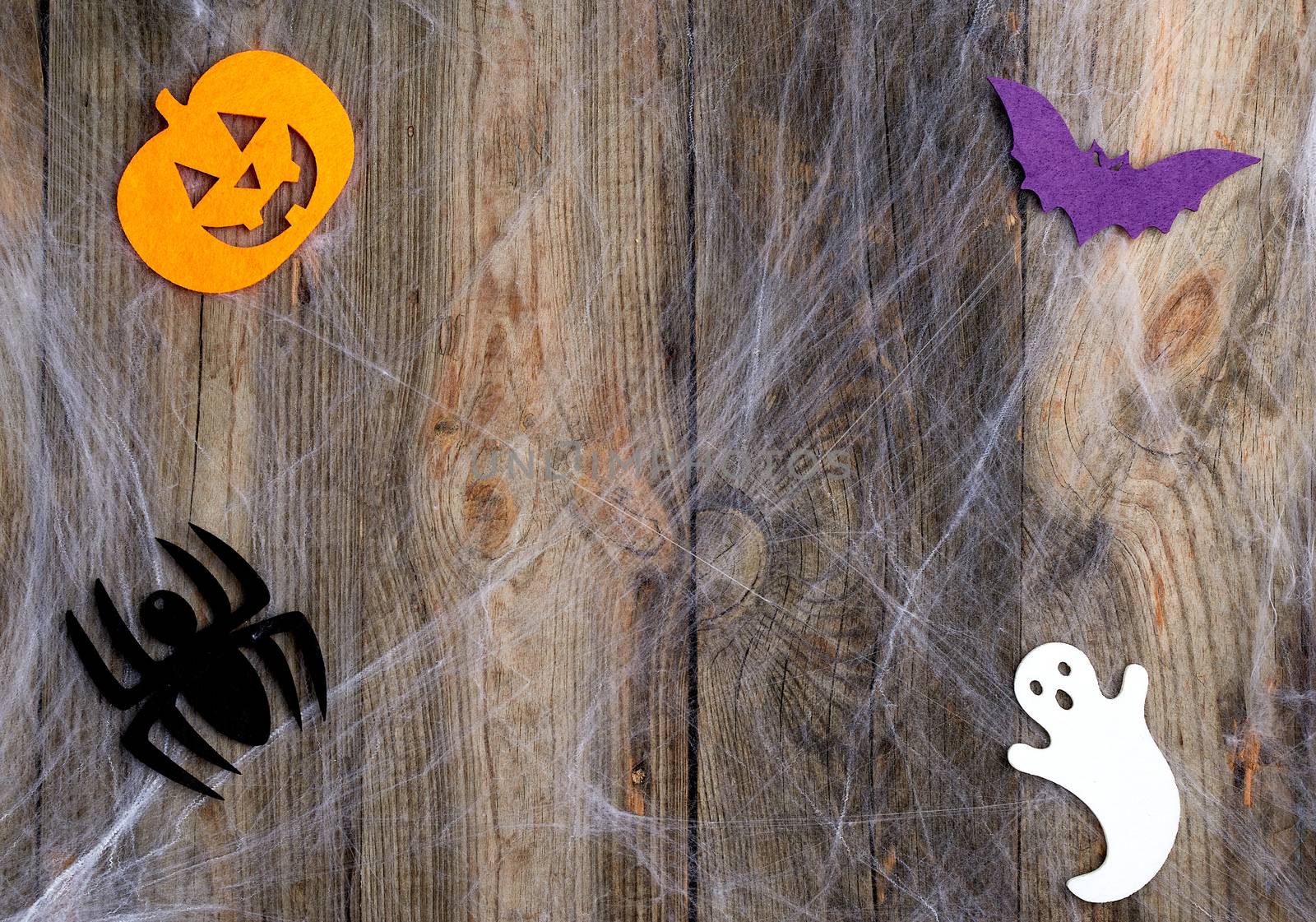 white spider web and carved pumpkin-shaped felt decor, backdrop for Halloween holiday