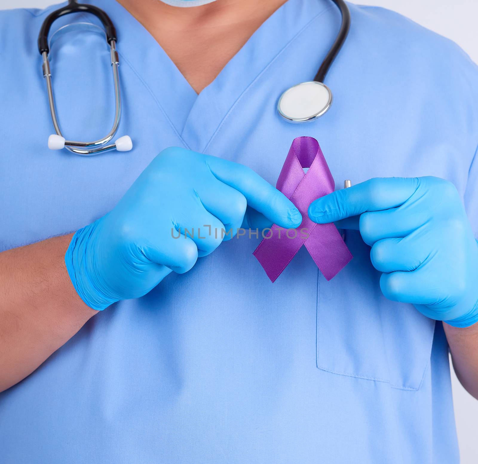 doctor in blue uniform and latex gloves holds a purple ribbon as a symbol of early research and disease control, Alzheimer's disease, cystic fibrosis, lupus, pancreatic cancer, sarcoidosis