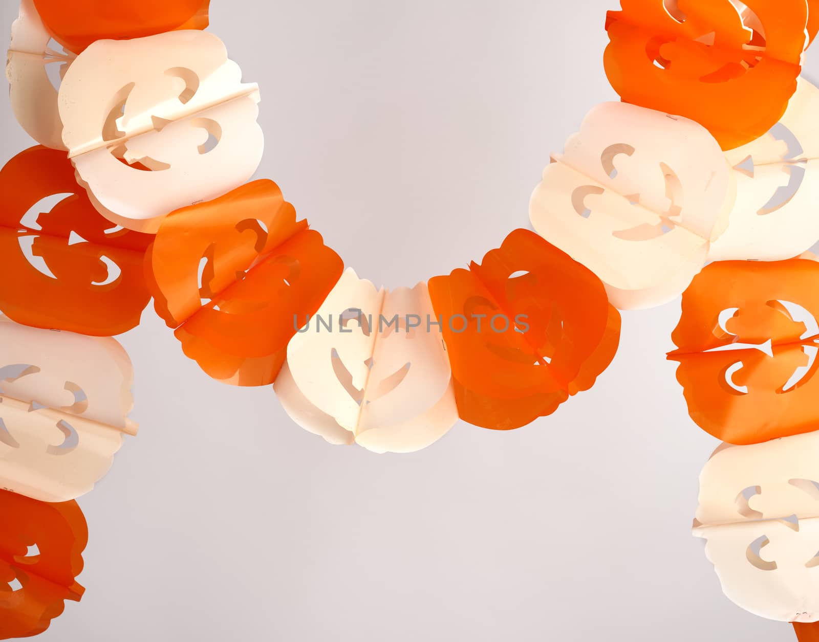 plastic garland on with carved figures of pumpkins, object is isolated on a white background, backdrop for Halloween