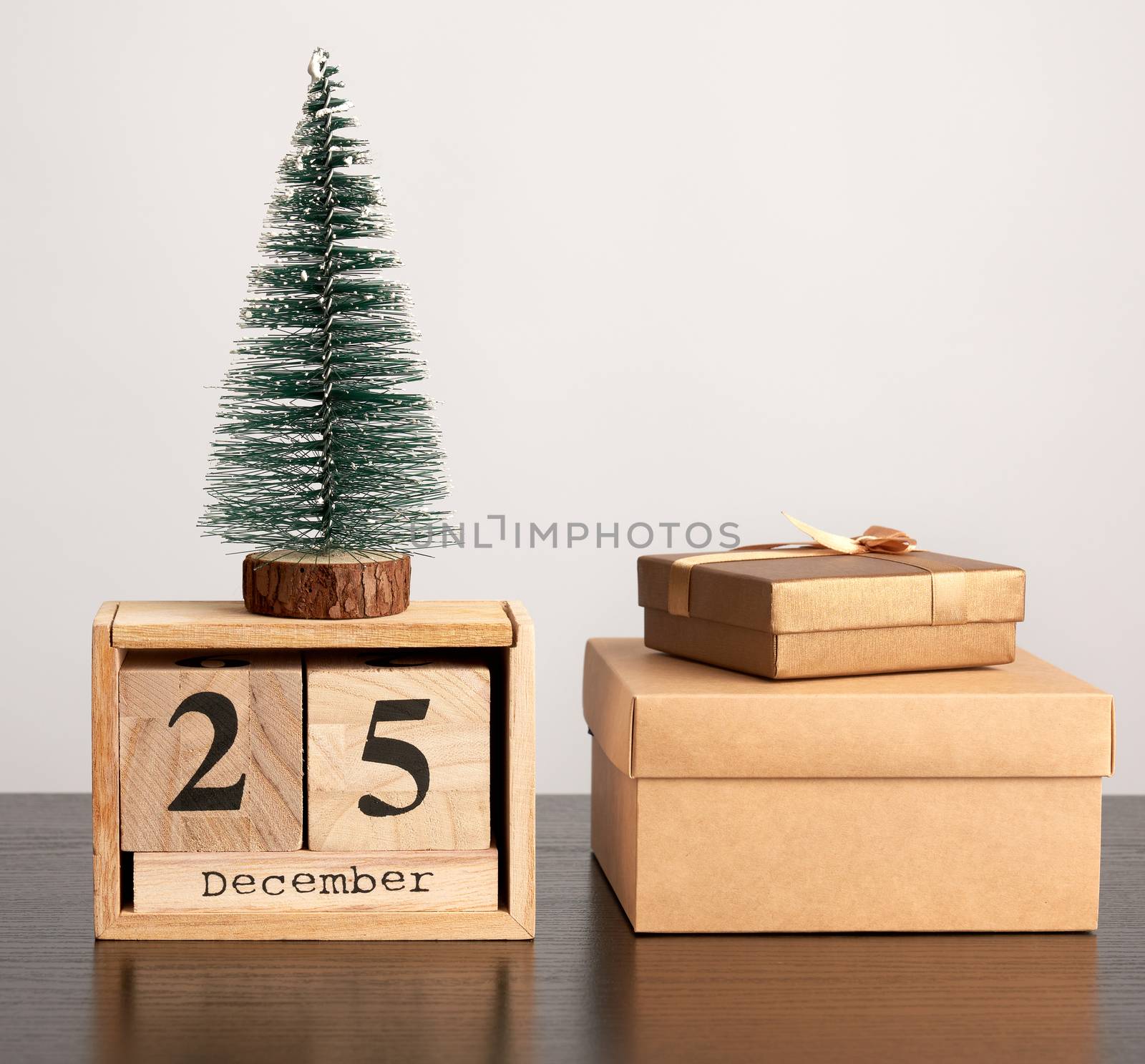 wooden retro calendar from blocks, Christmas decorative tree and cardboard boxes with gifts, white background